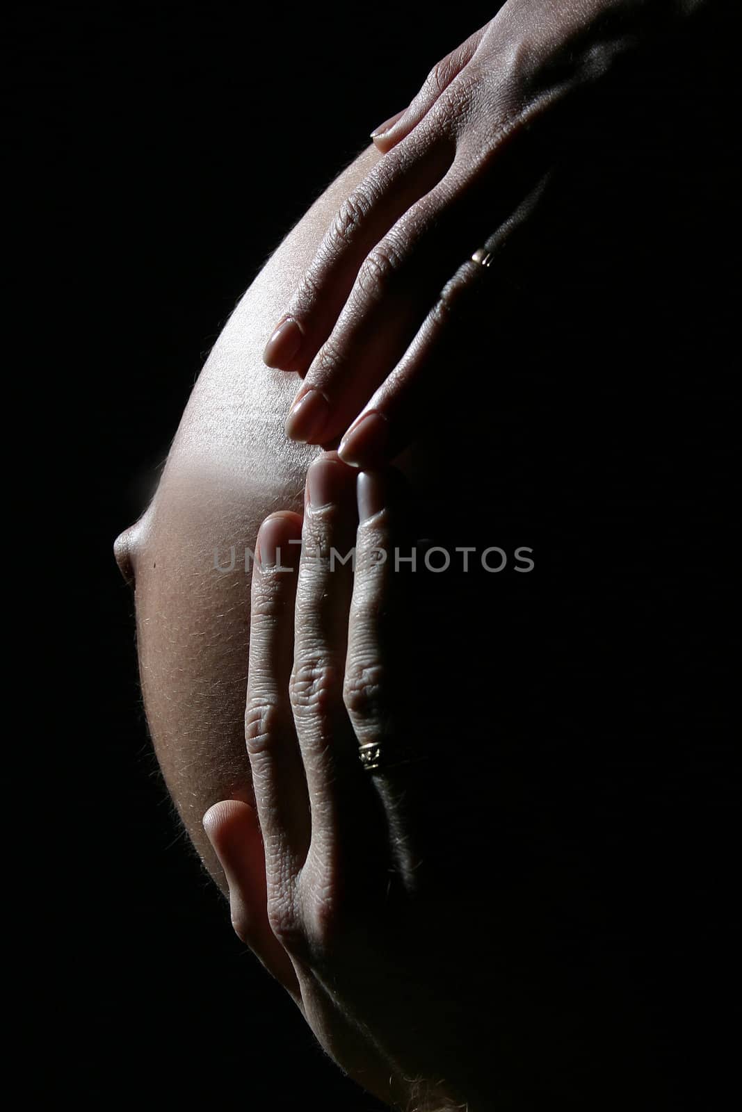 Two hands are giving warmth to unborn baby.
