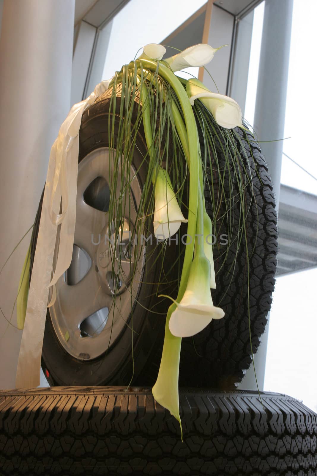 Brides bouquet of calla on the tires of car.