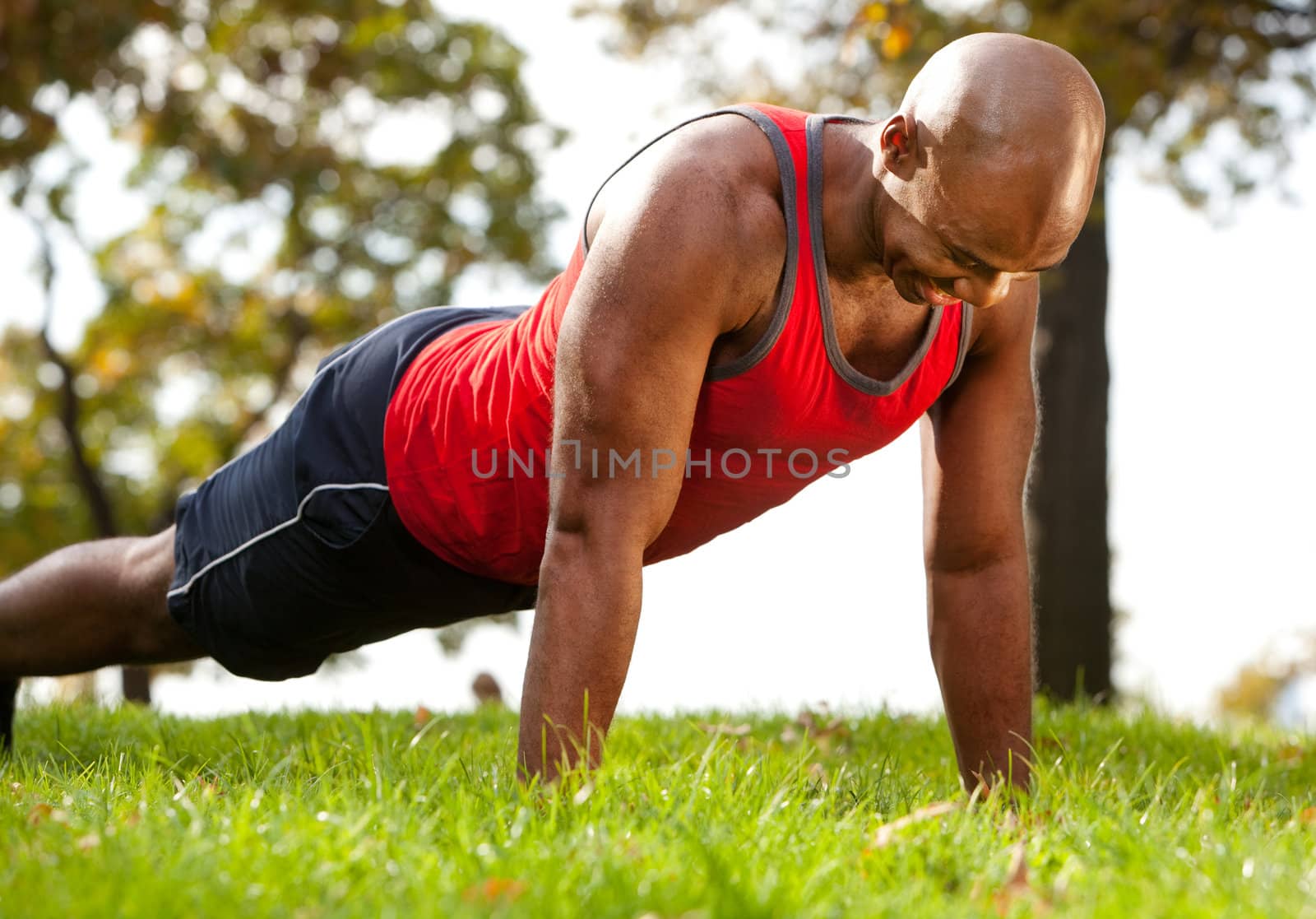 A man doing a push up in a park