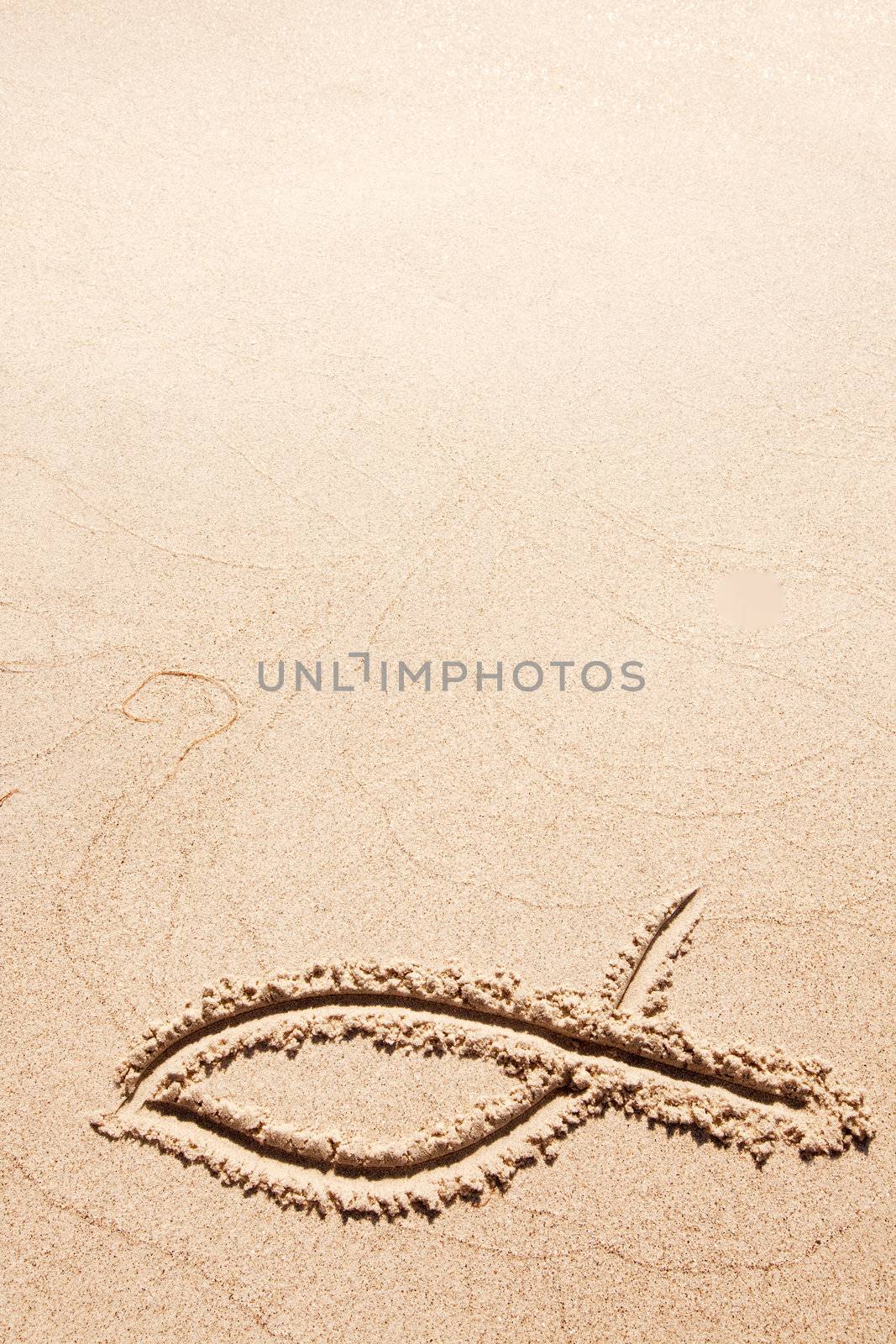 A fish symbol in drawn in the sand