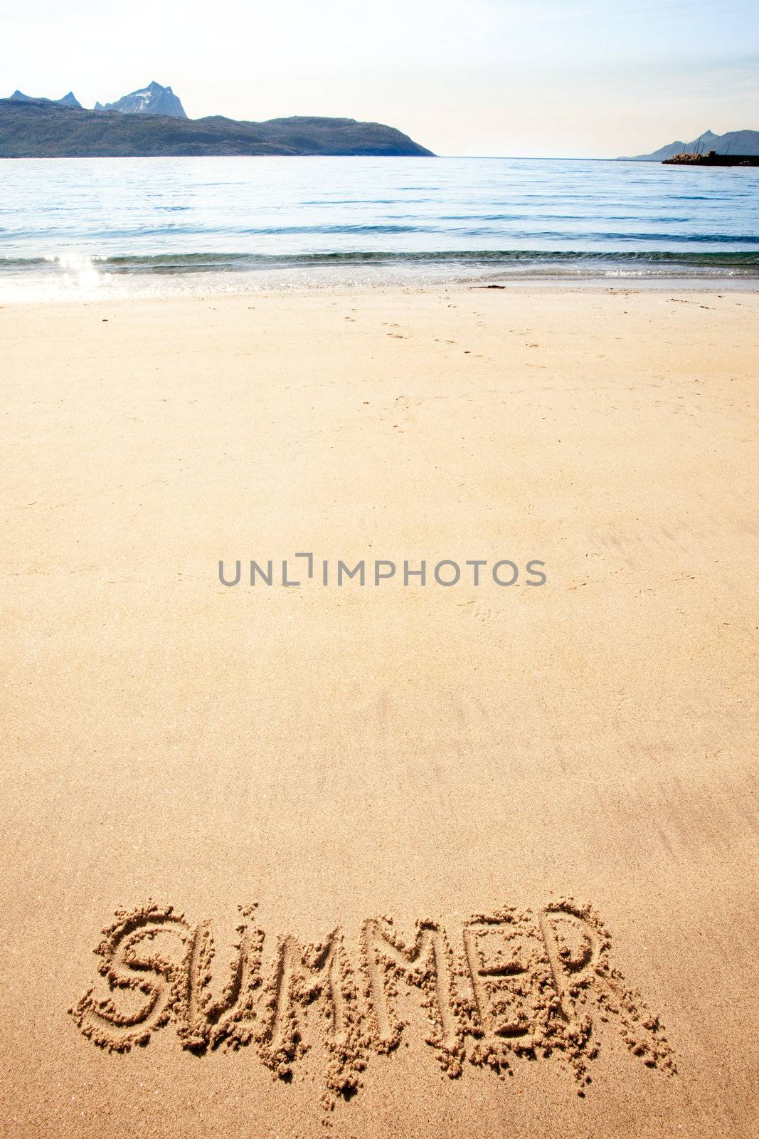 The word summer written in the sand at a beach