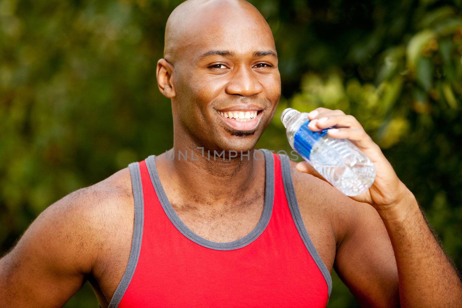 A man exercising in the park, taking a break