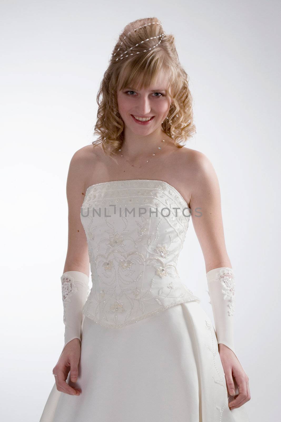 Beautiful bride in white dress with charming smile  on the white background.