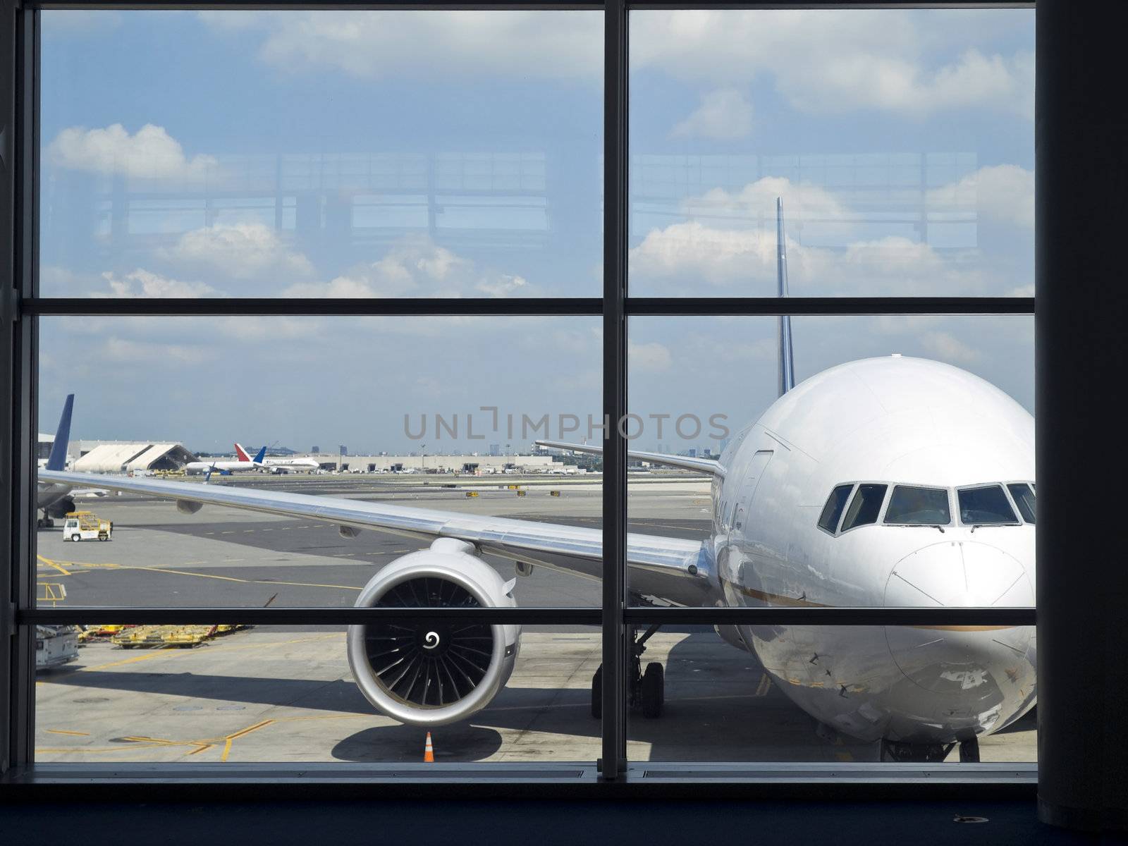 Parked aircraft on an airport through the gate window.