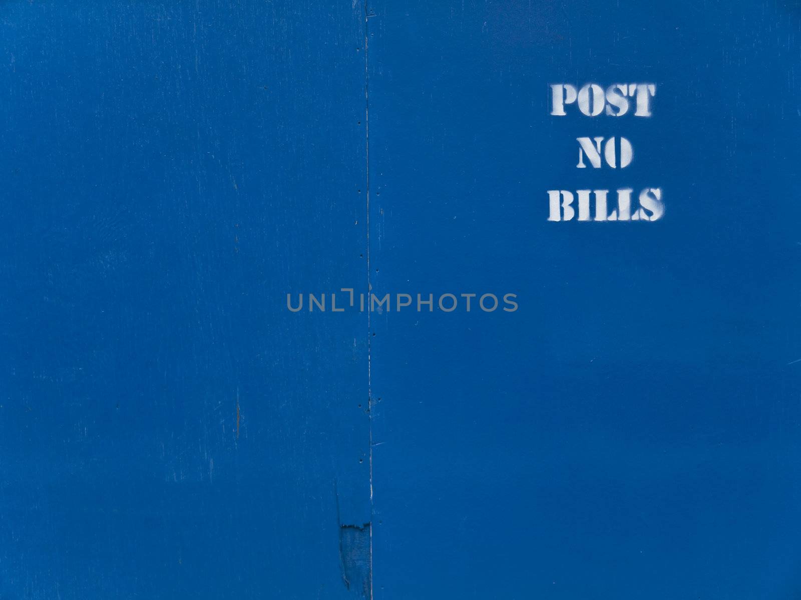 Blue wooden panel background with a white stenciled "post no bills" text.