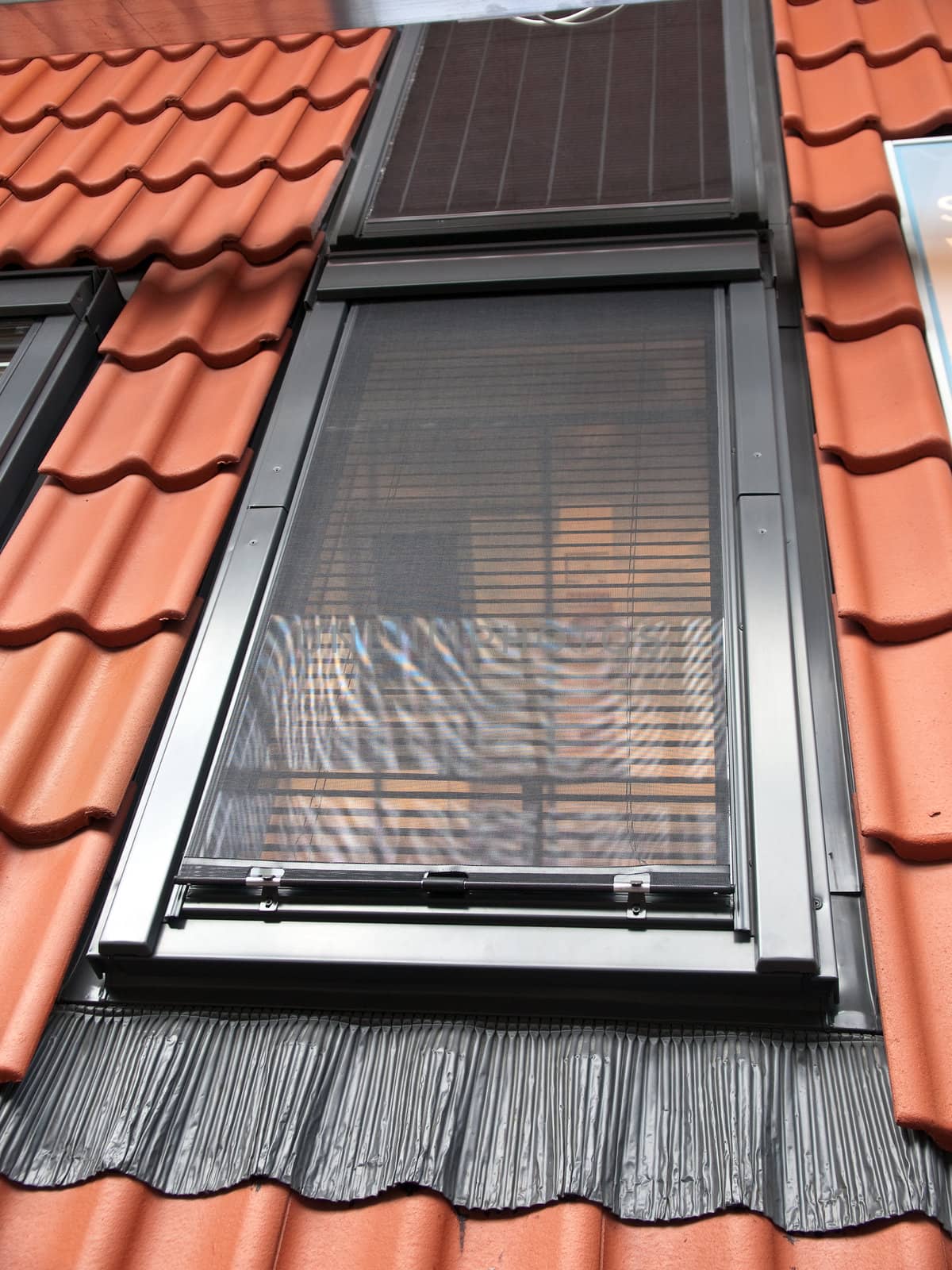 Modern vertical roof window with red tiles