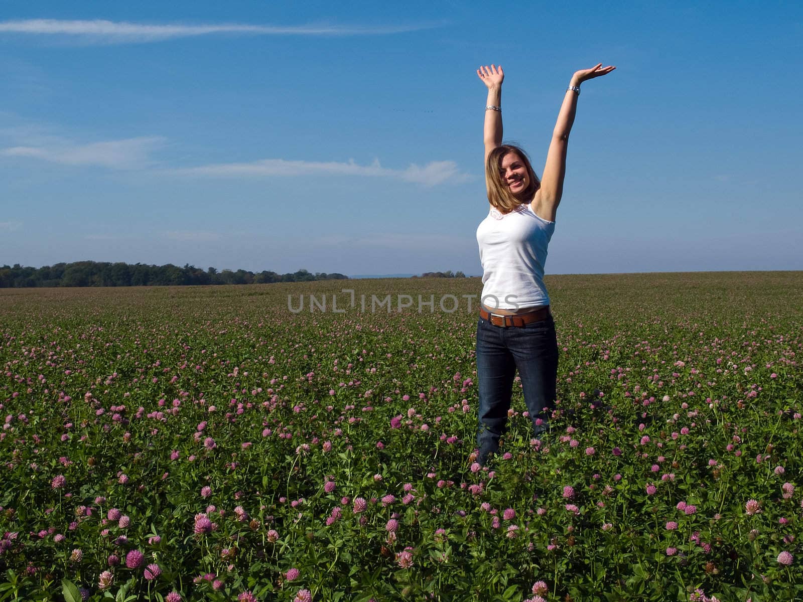 Beautiful attractive young happy woman girl in a sunny flowers field