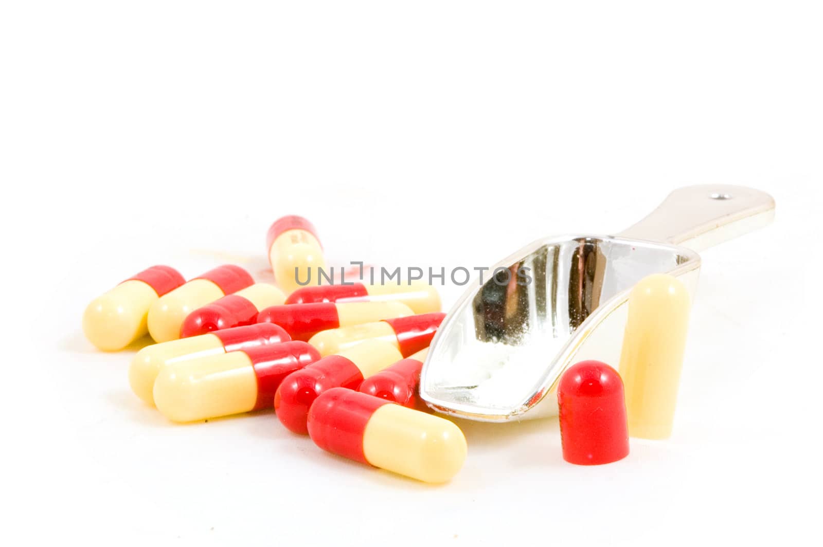 Pills with measure scoop on a white background
