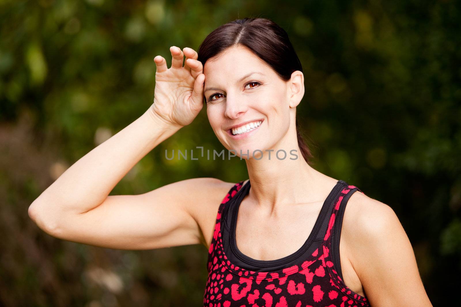 A woman exercising in a park, taking a break