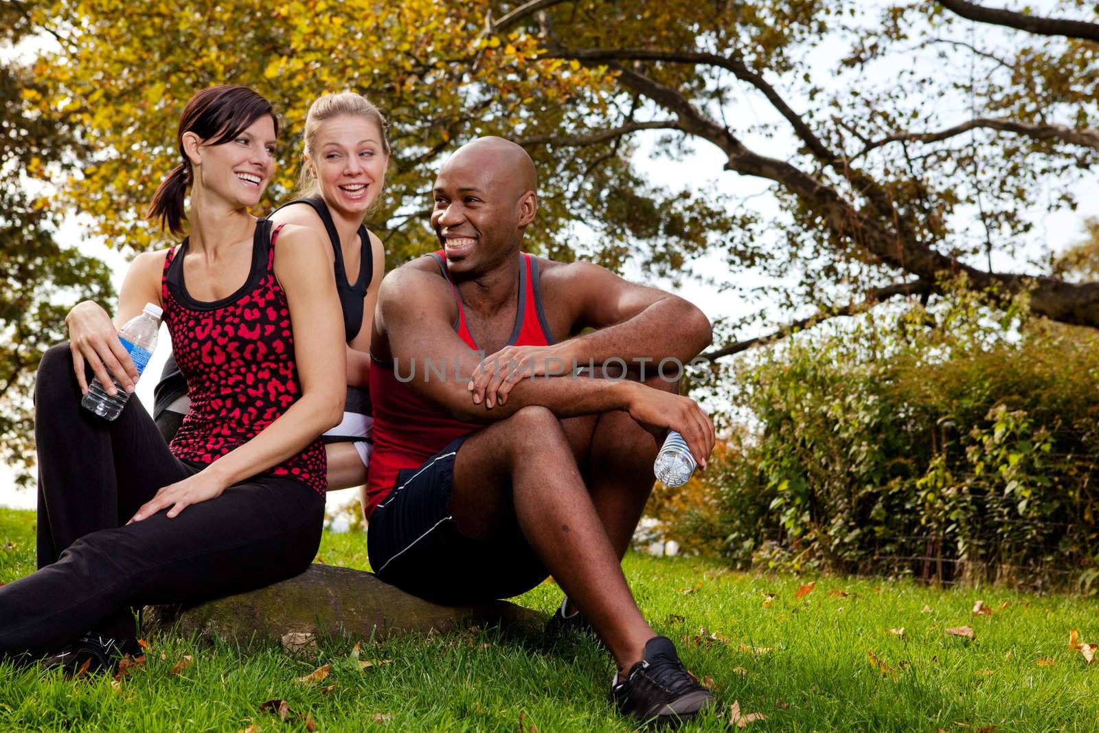 A group of young adults resting after exercise in the park