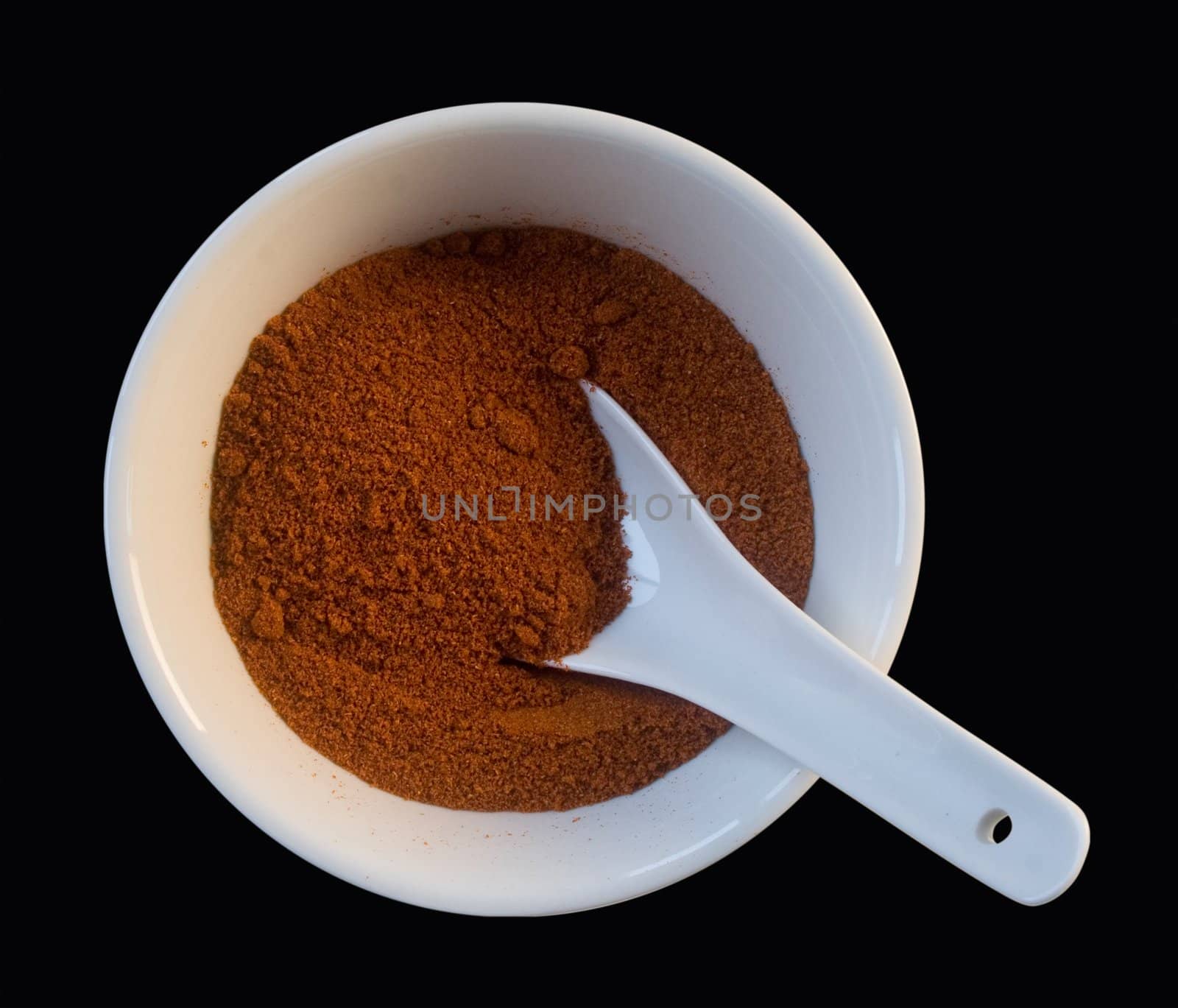grounded red pepper in white cup isolated on black