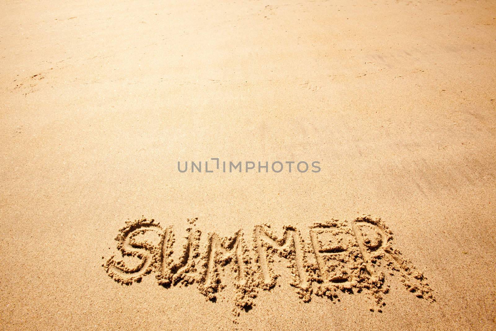 The word summer written in the sand at a beach