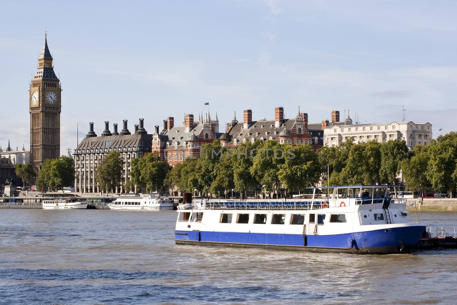 View of The Big Ben, houses and a boat in the river Thames in London