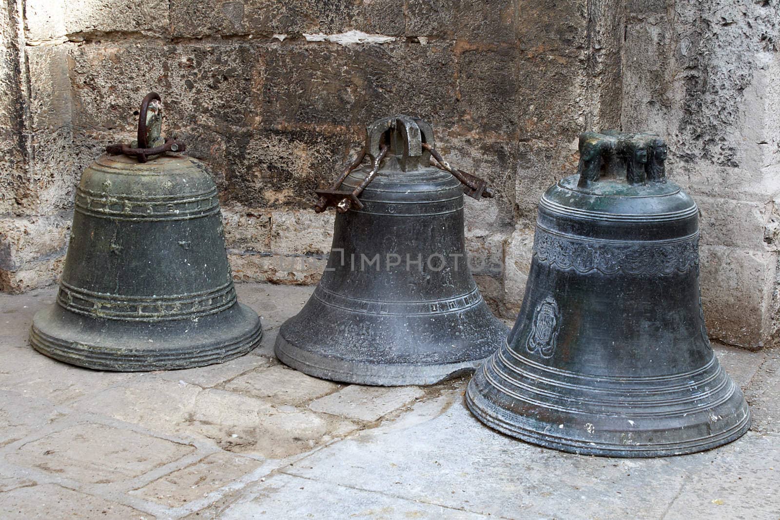 Three old bronze bells standing in the floor