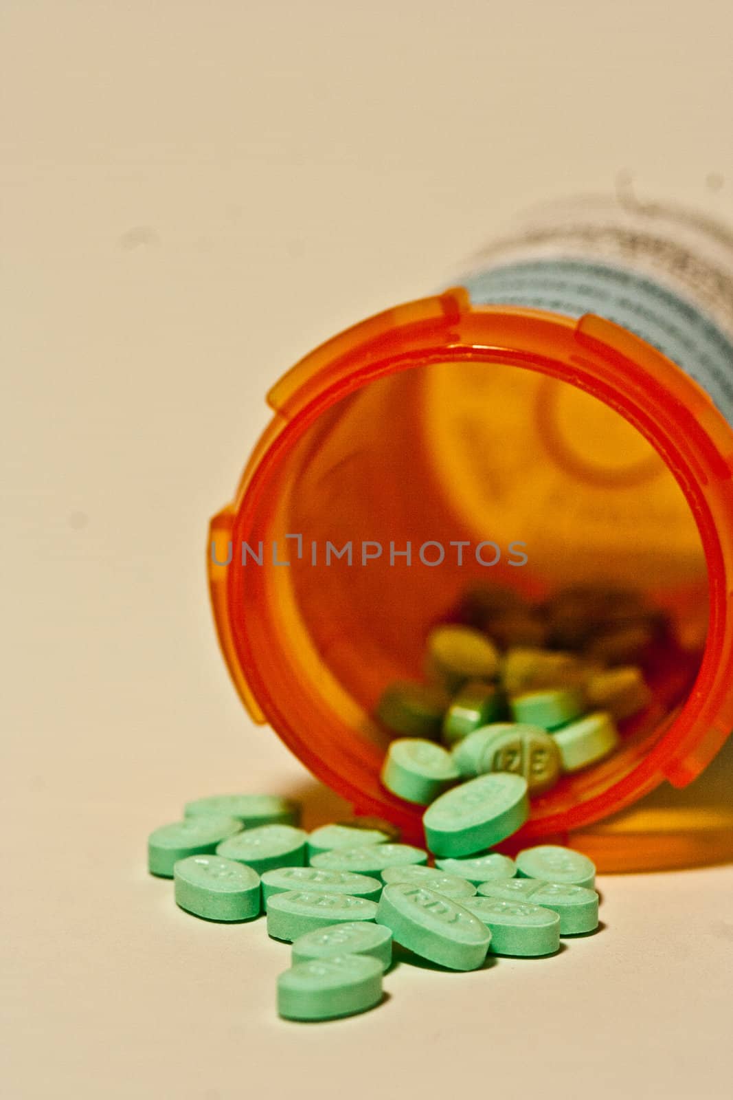 Drugs in pill form coming out of a fallen bottle.