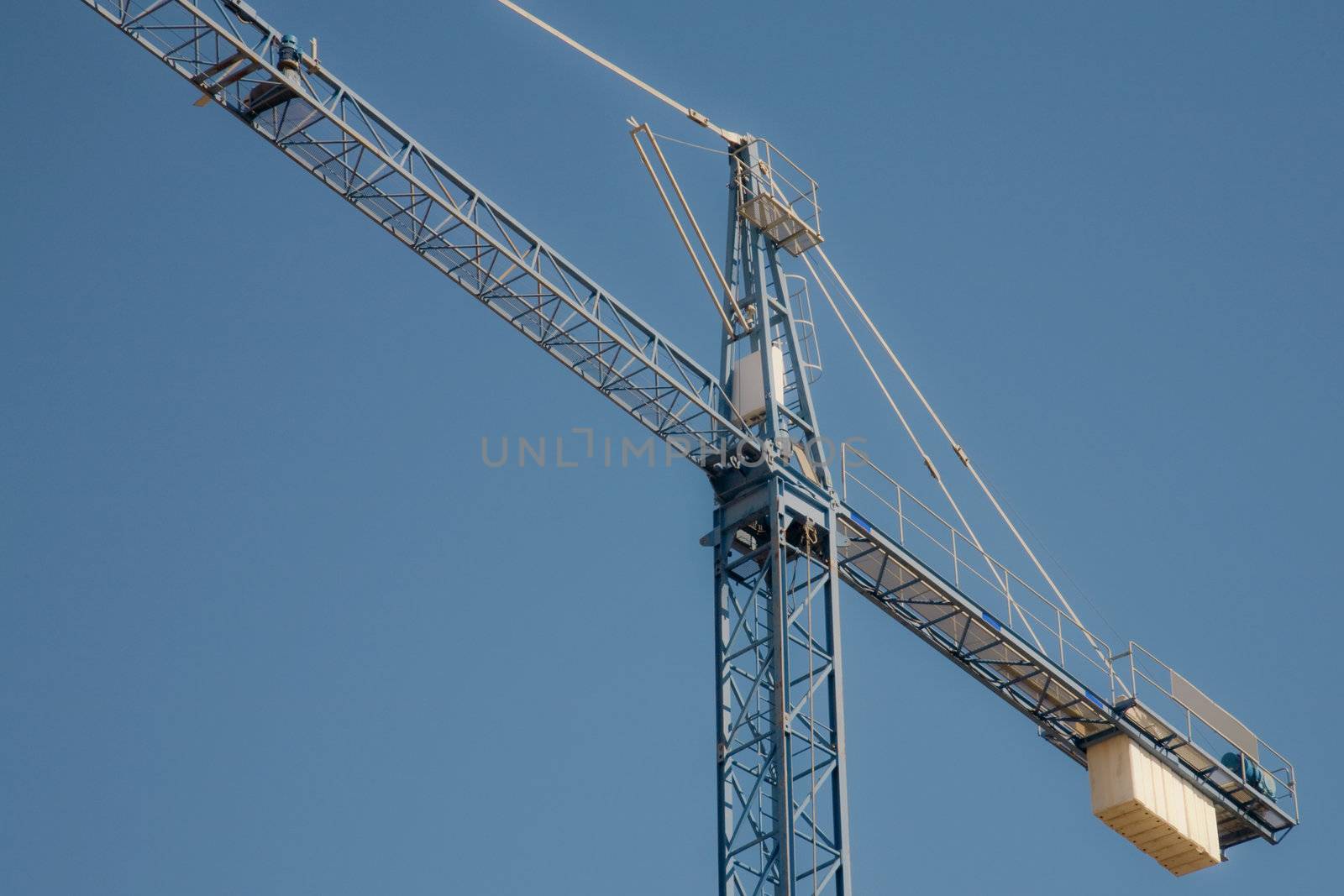 Crane on a clear blue sky background with lots of copy-space.