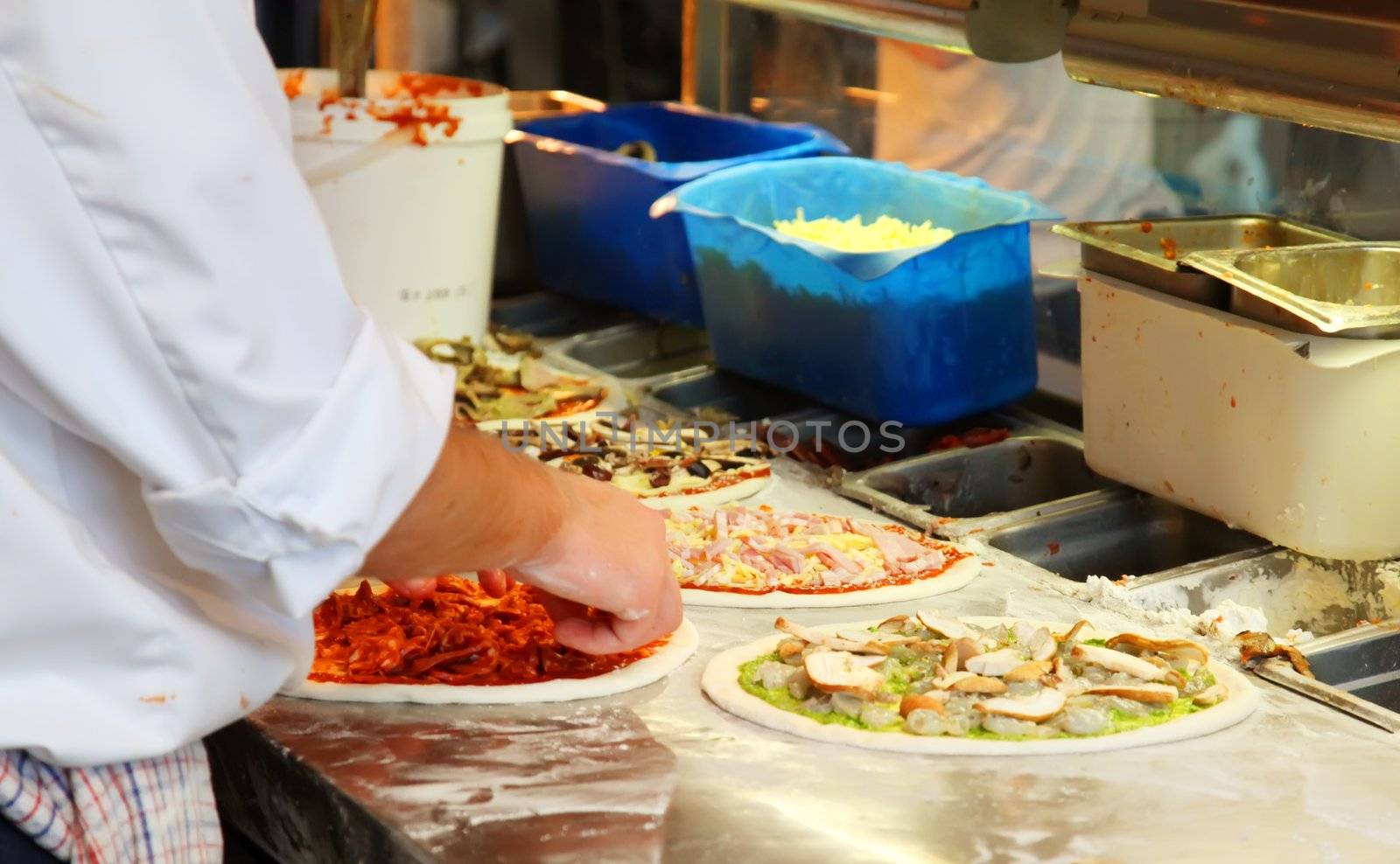 Chef Making Assorted Pizzas in a Restaurant