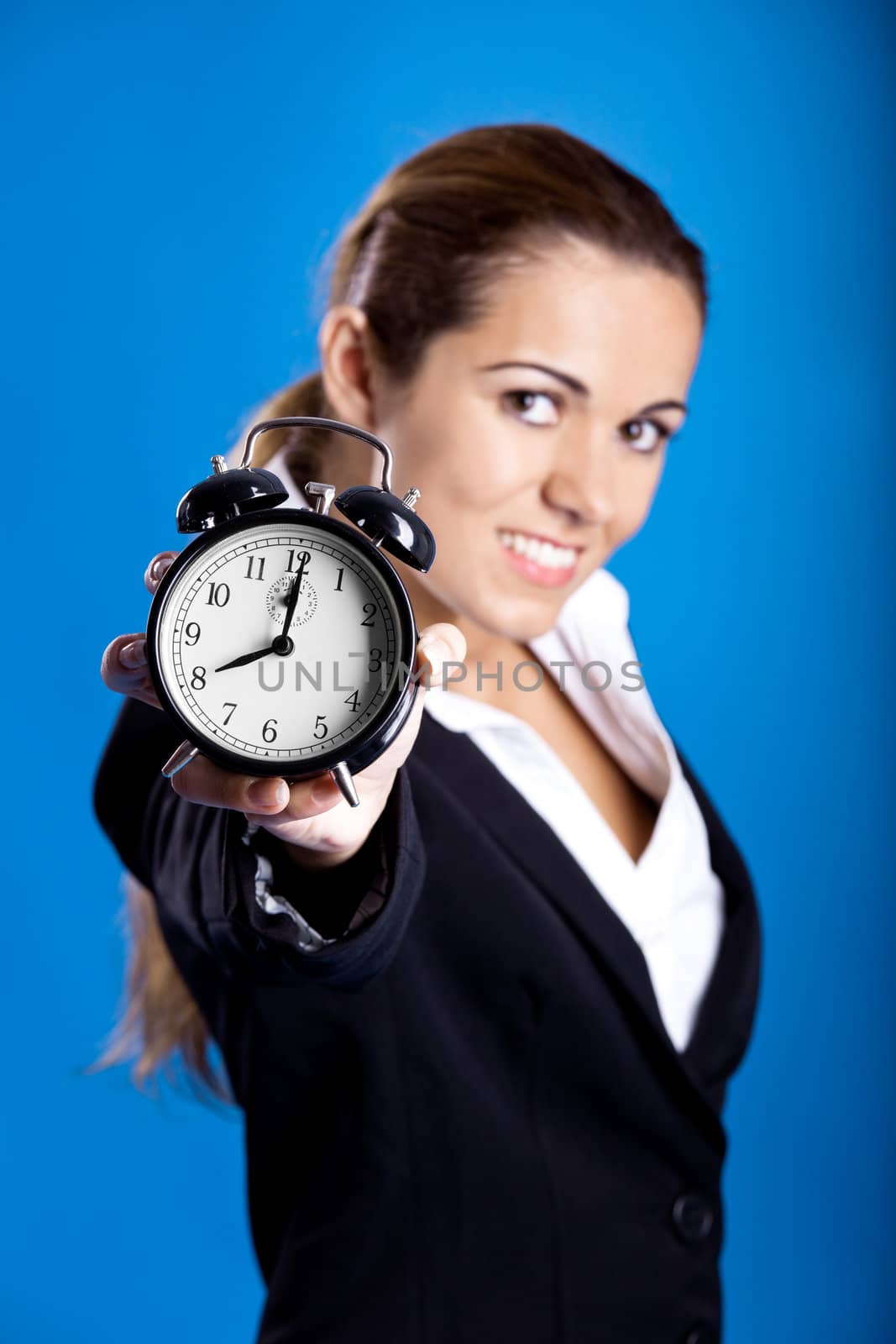 Portrait of a beautiful and young businesswoman holding an hold clock, focus on the clock
