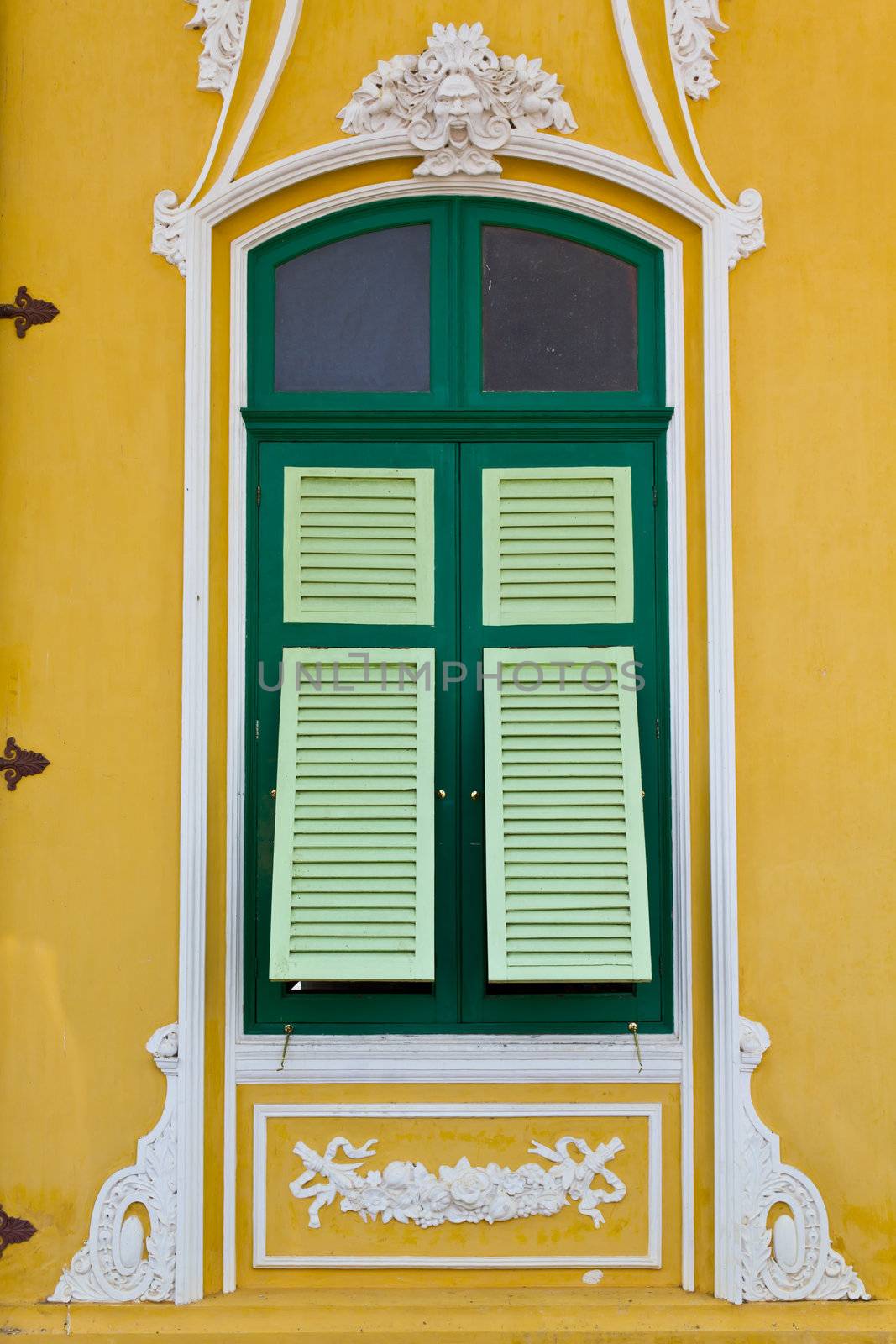 the closed green window on the yellow wall  by lavoview