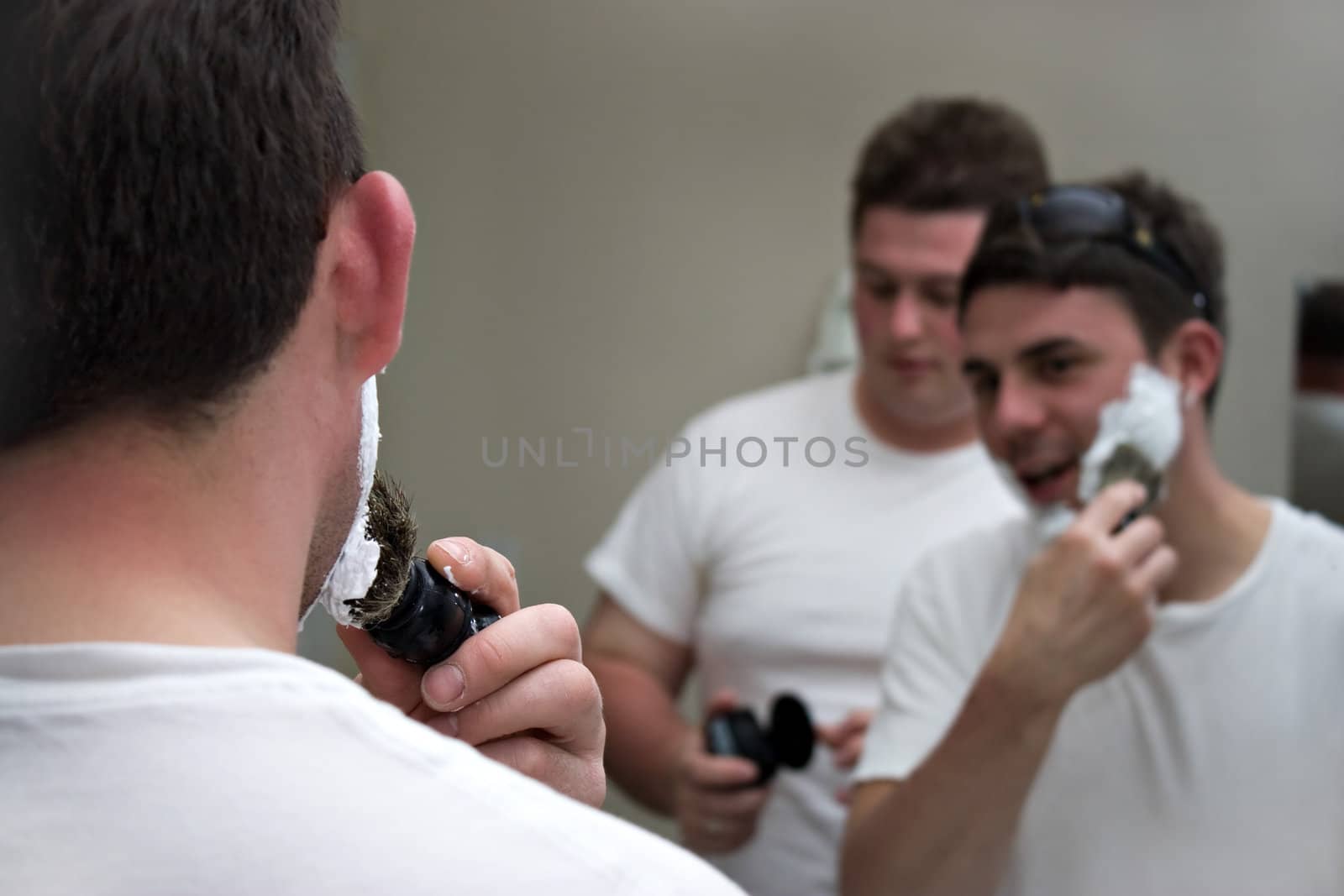 Two groomsmen shaving and gettin ready for the big event.  Shallow depth of field with focus on the foreground.