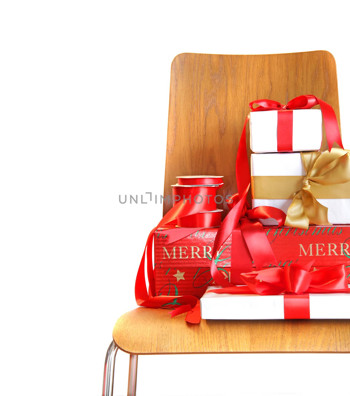 Pile of gifts on wooden chair against white background