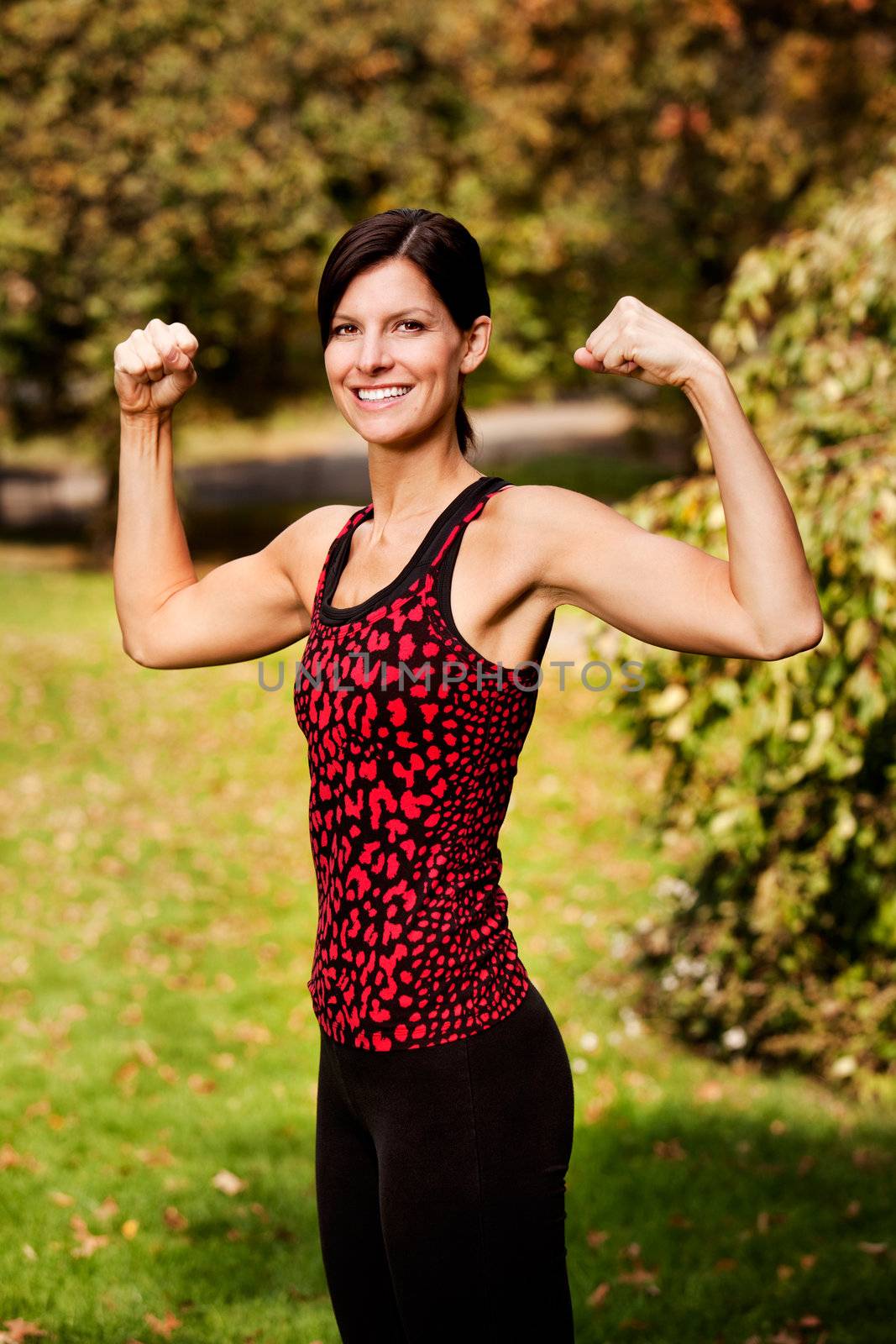 A portrait of a woman flexing her bicep muscles