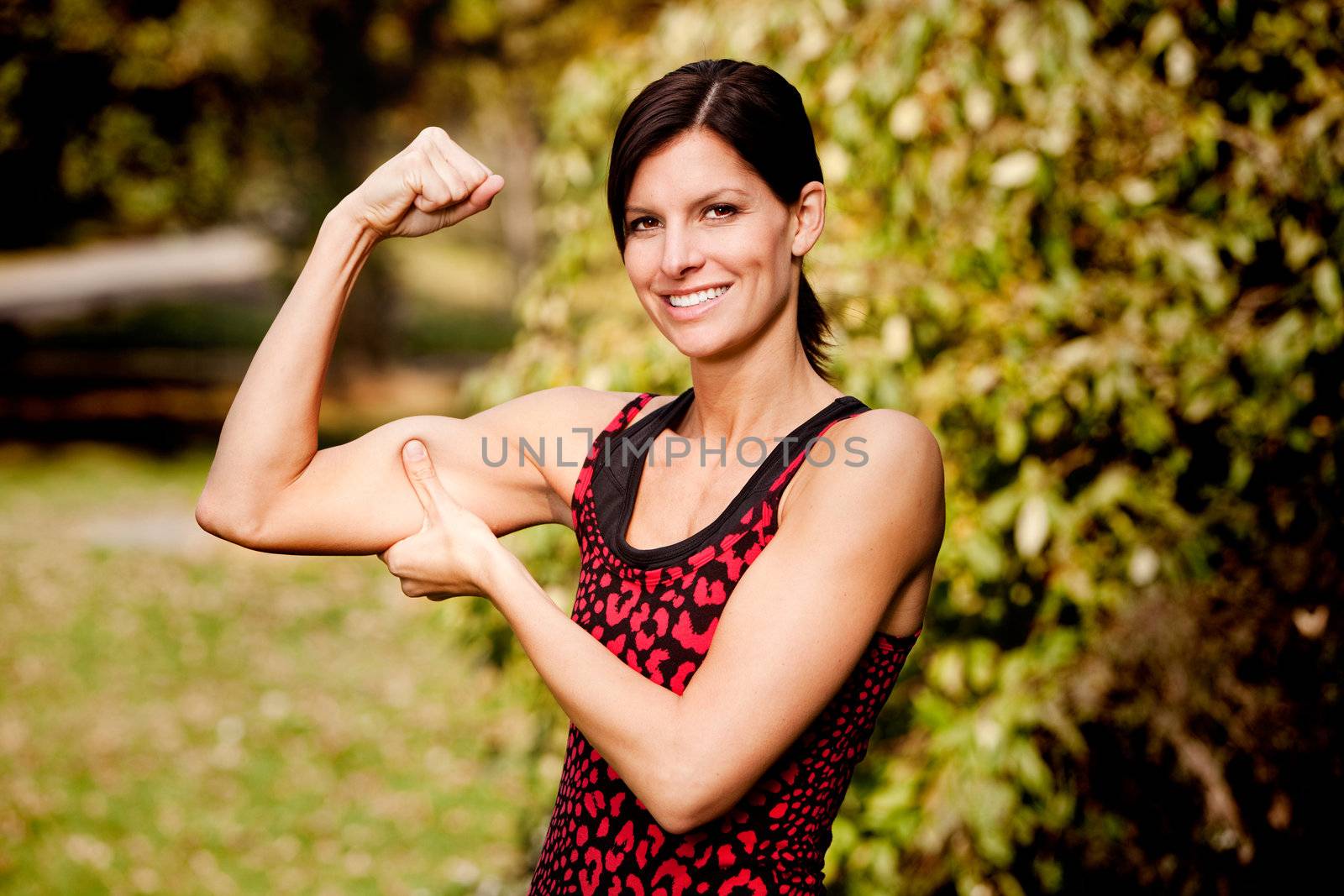 A woman flexing her biscep and making it larger