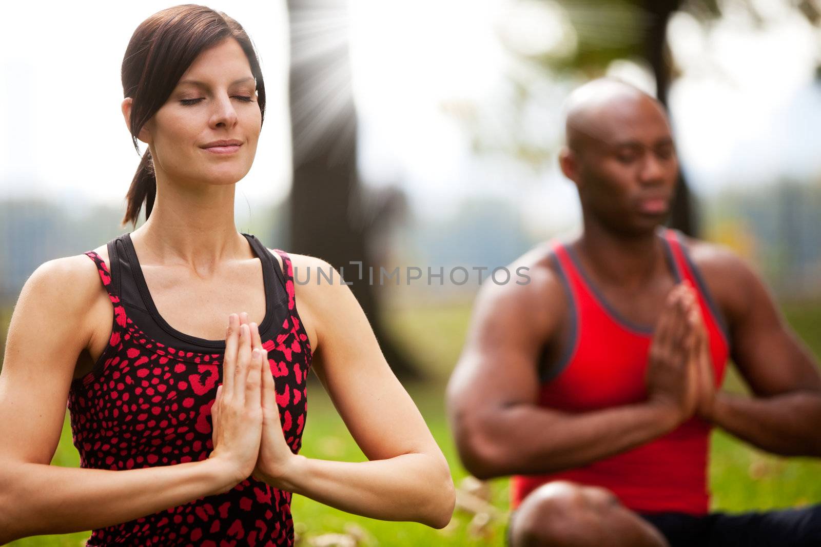 A group of people peacefully meditating in a park