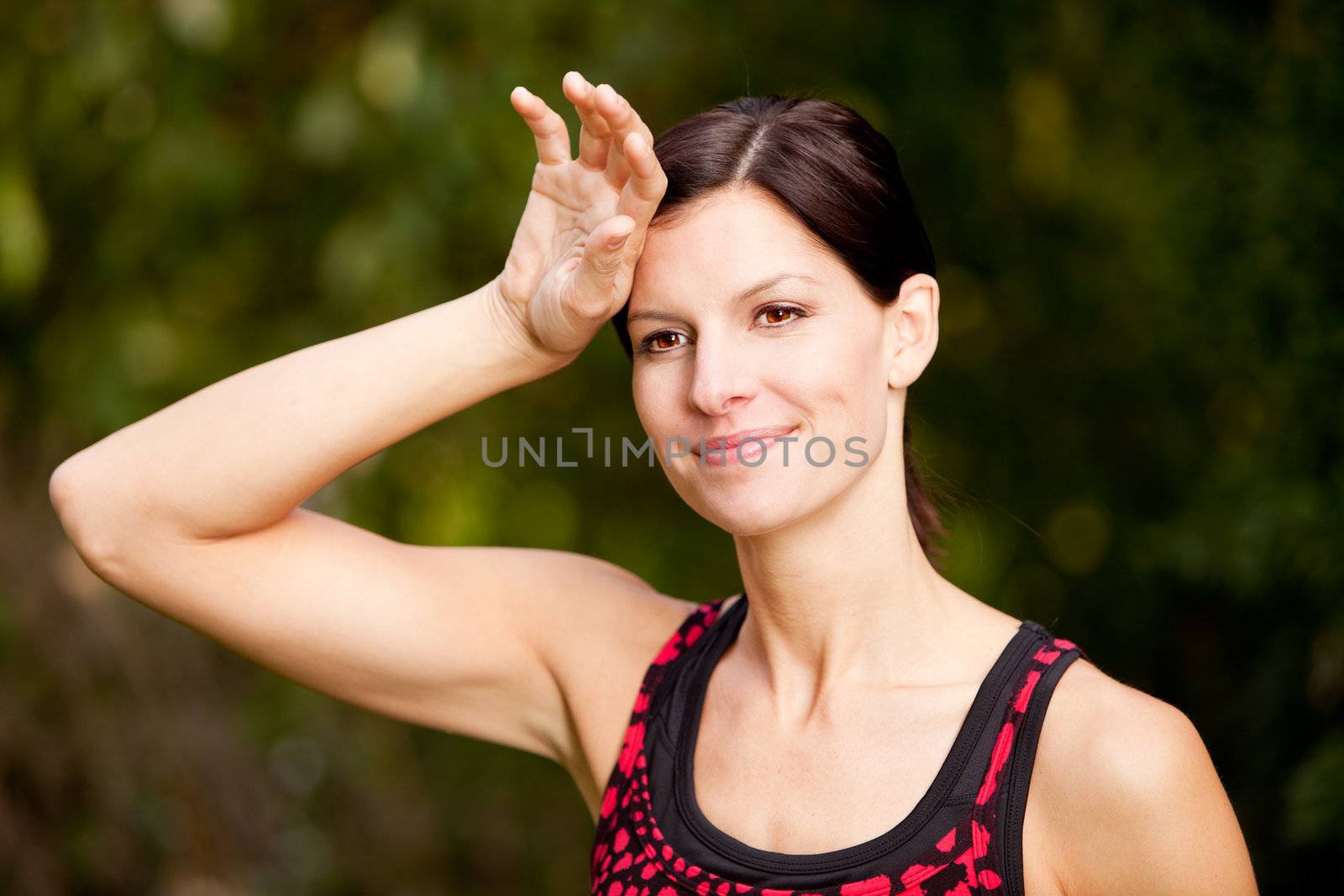 A woman exercising in a park, taking a break