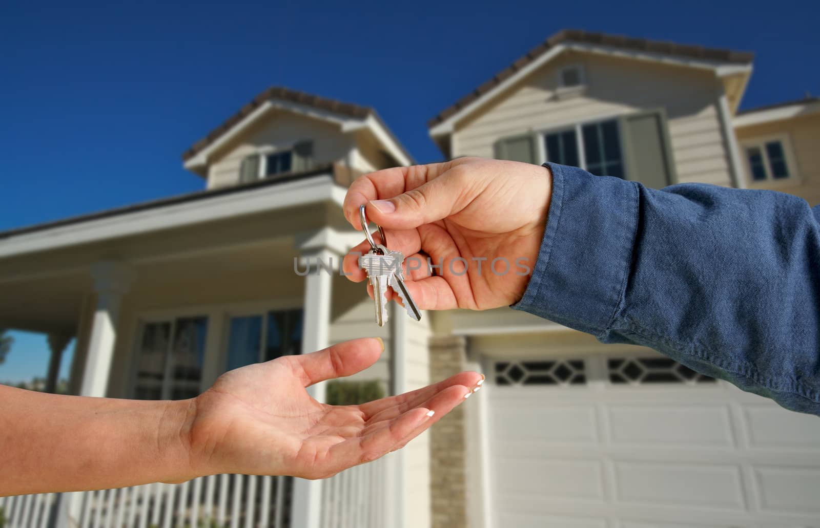 Handing Over the House Keys in Front of a Beautiful New Home.