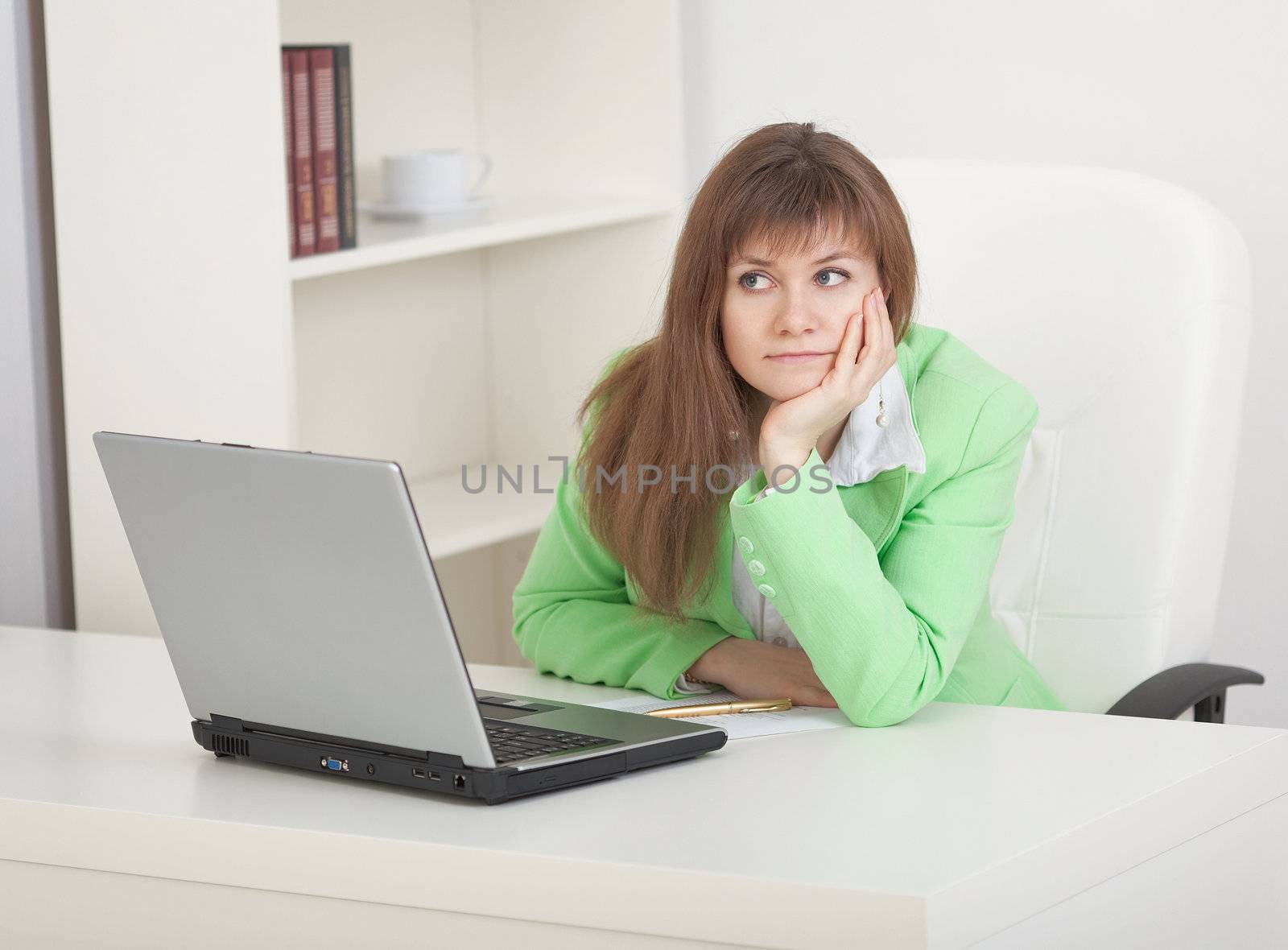 Young businesswoman sits on a workplace and misses