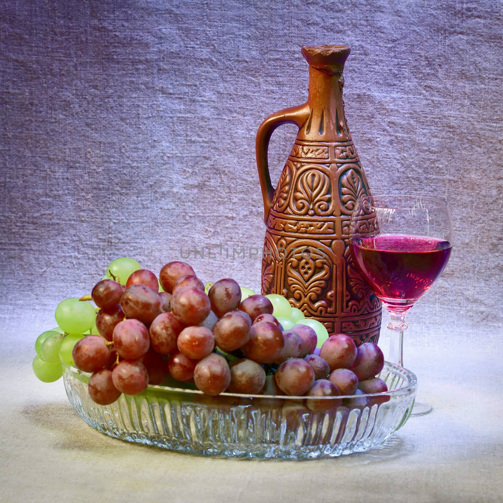 Still-life with a clay bottle, grapes and a glass
