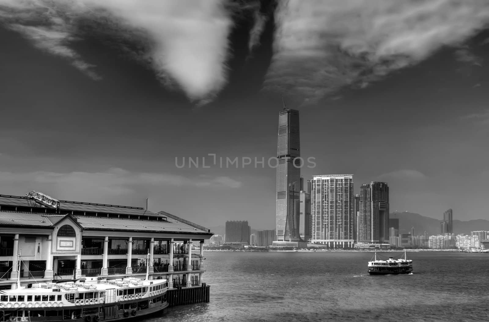 Black and white cityscape that one ferry berthed at Victoria Harbor in Hong Kong.