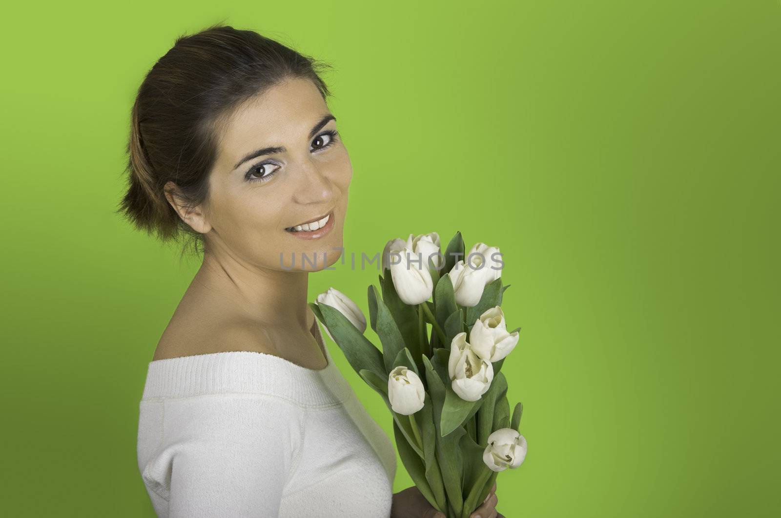 Beautiful woman on a green background with white tulips on the hands