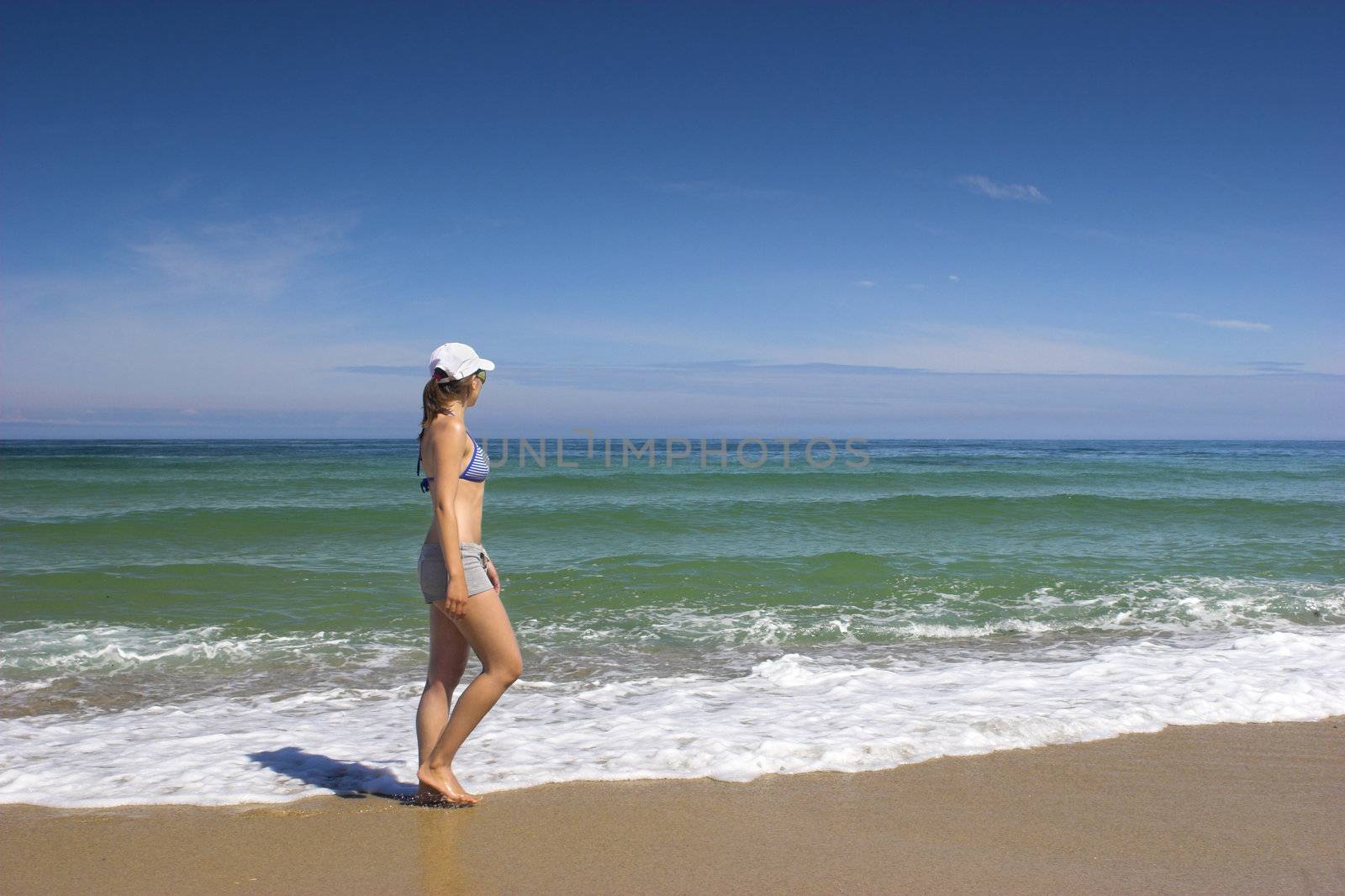 Beautiful woman walking on the beach feeling the breeze