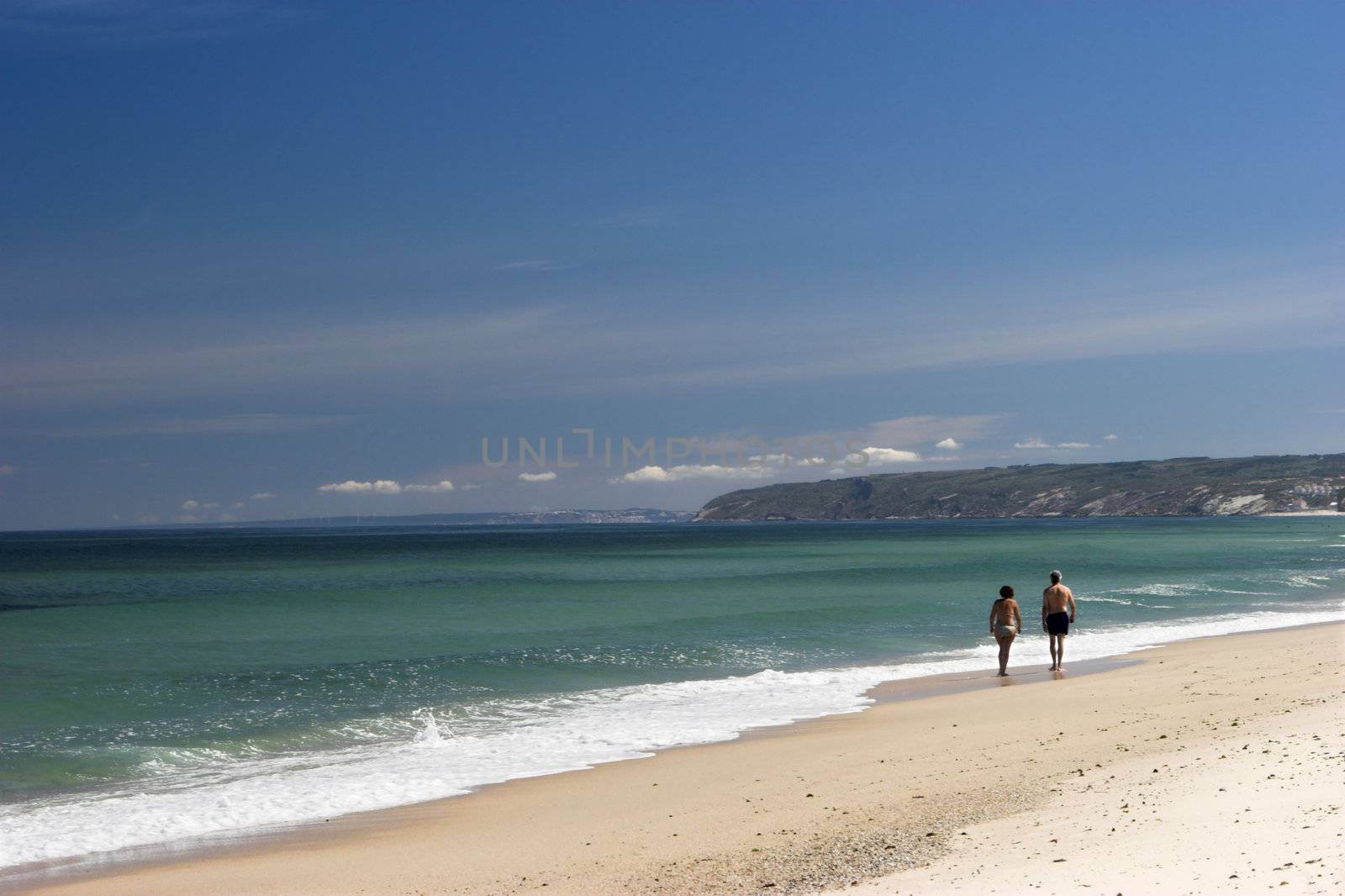 Couple walking on the white sand in a beautiful beach