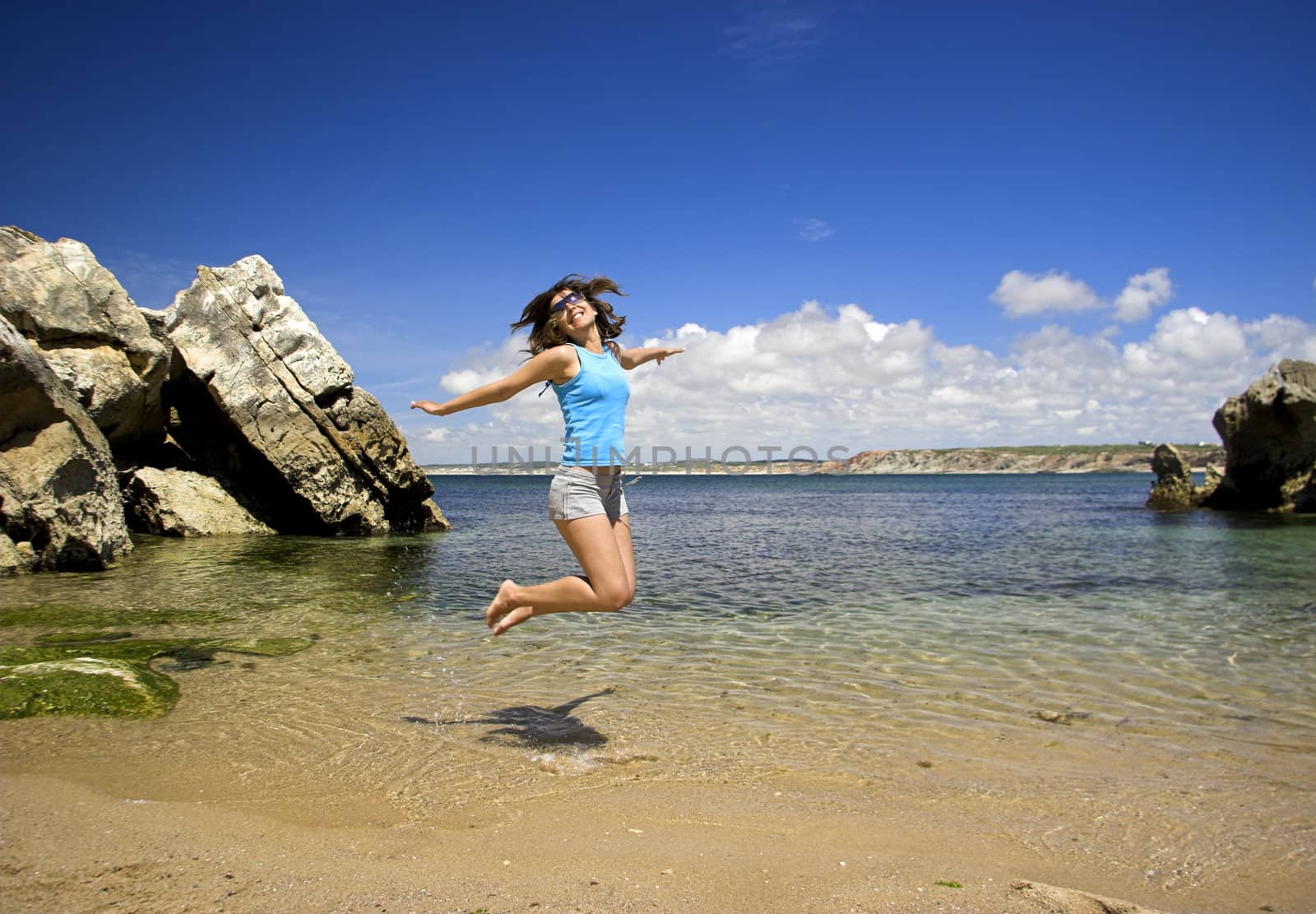 Beautiful young woman jumping on a beautiful beach