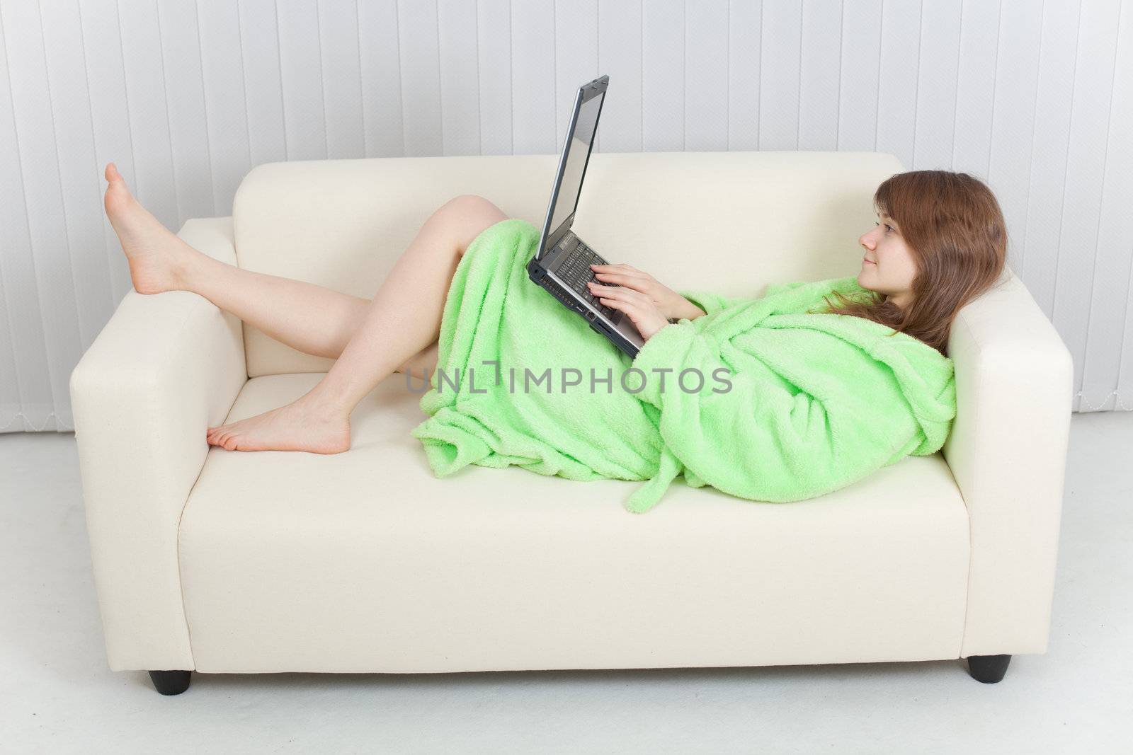 Young woman with portable computer on a sofa by pzaxe