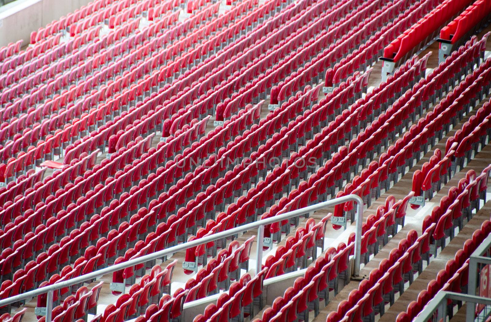 Rows of empty red seats in a football stadium