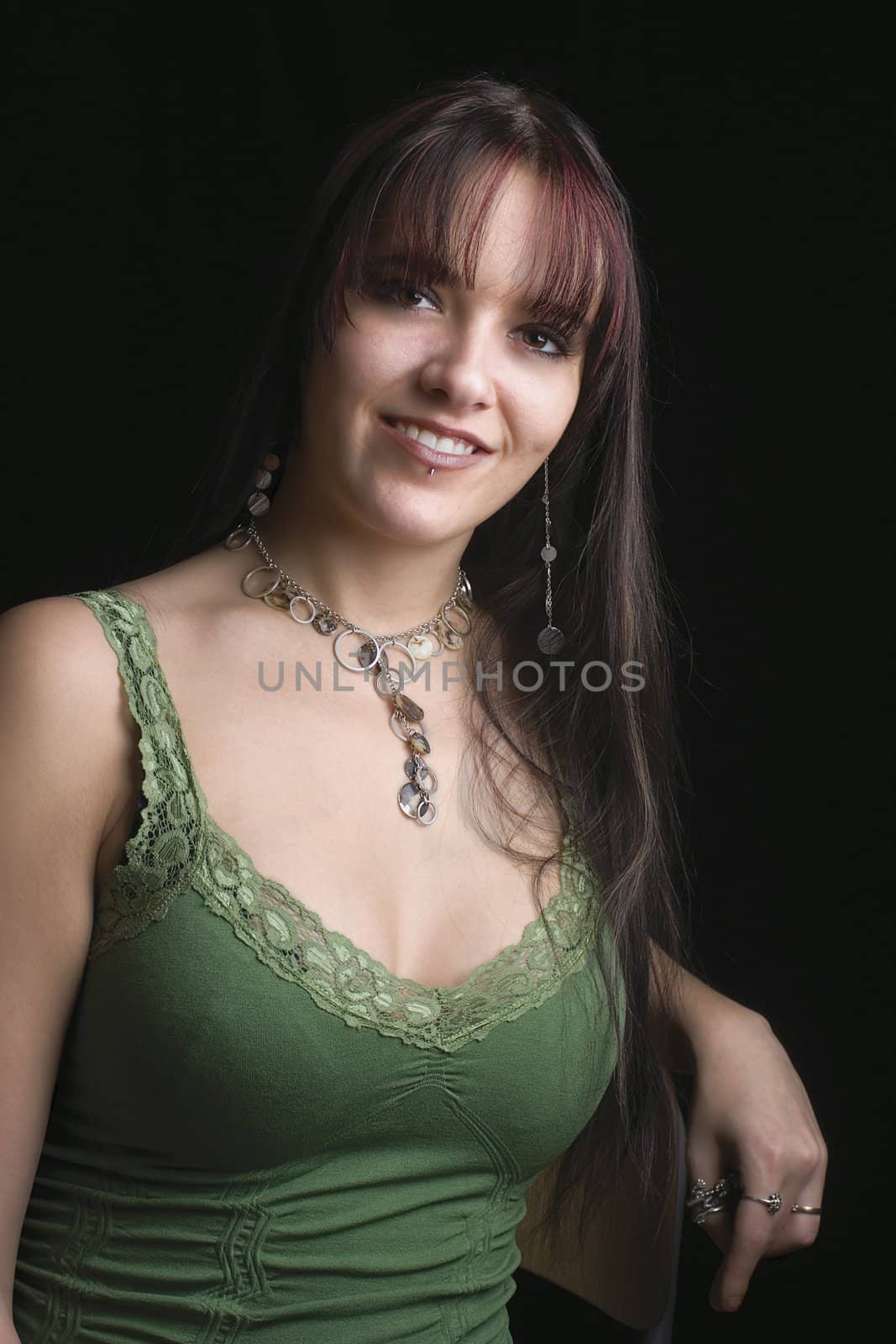 Portrait of fashion model in relaxe position with green tank top, sitting on a chair