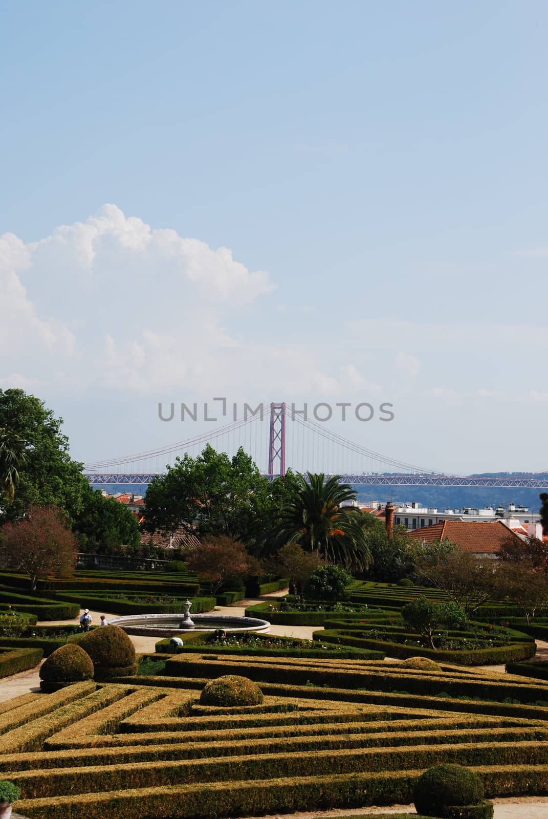 beautiful ornamental Ajuda garden with April 25th bridge on background in Lisbon, Portugal