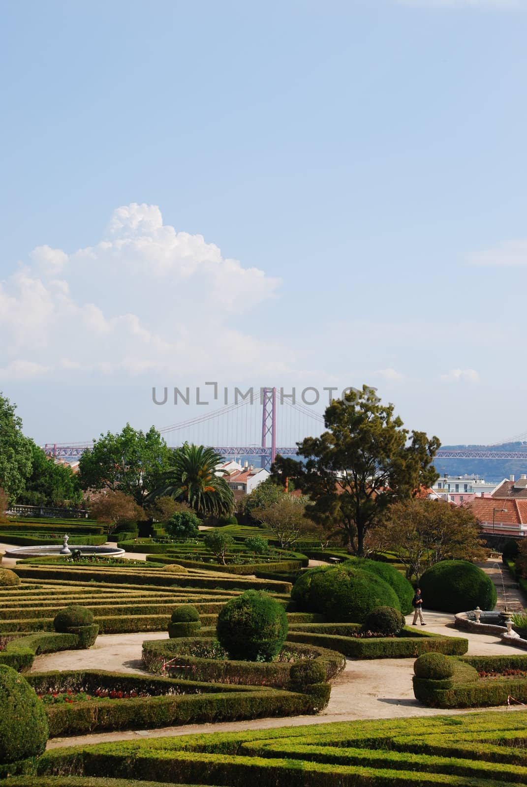 beautiful ornamental Ajuda garden with April 25th bridge on background in Lisbon, Portugal