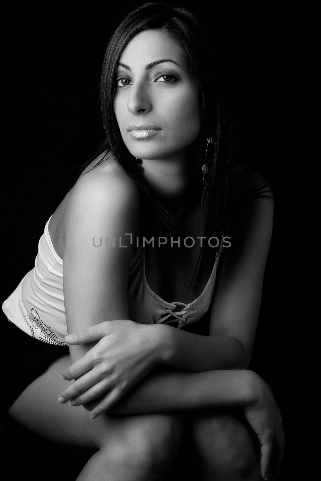 Black and white photo of a twenty something fashion model sitting on office chair with secretary style