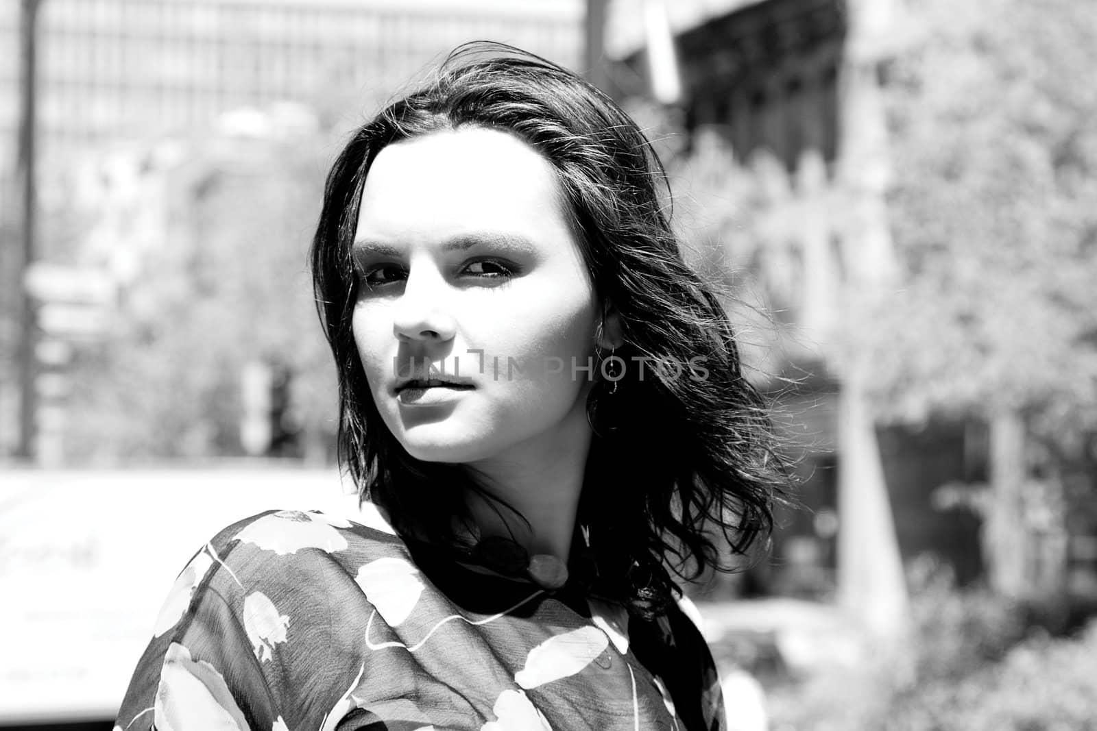 Black and white portrait of a twenty something girl with a urban background