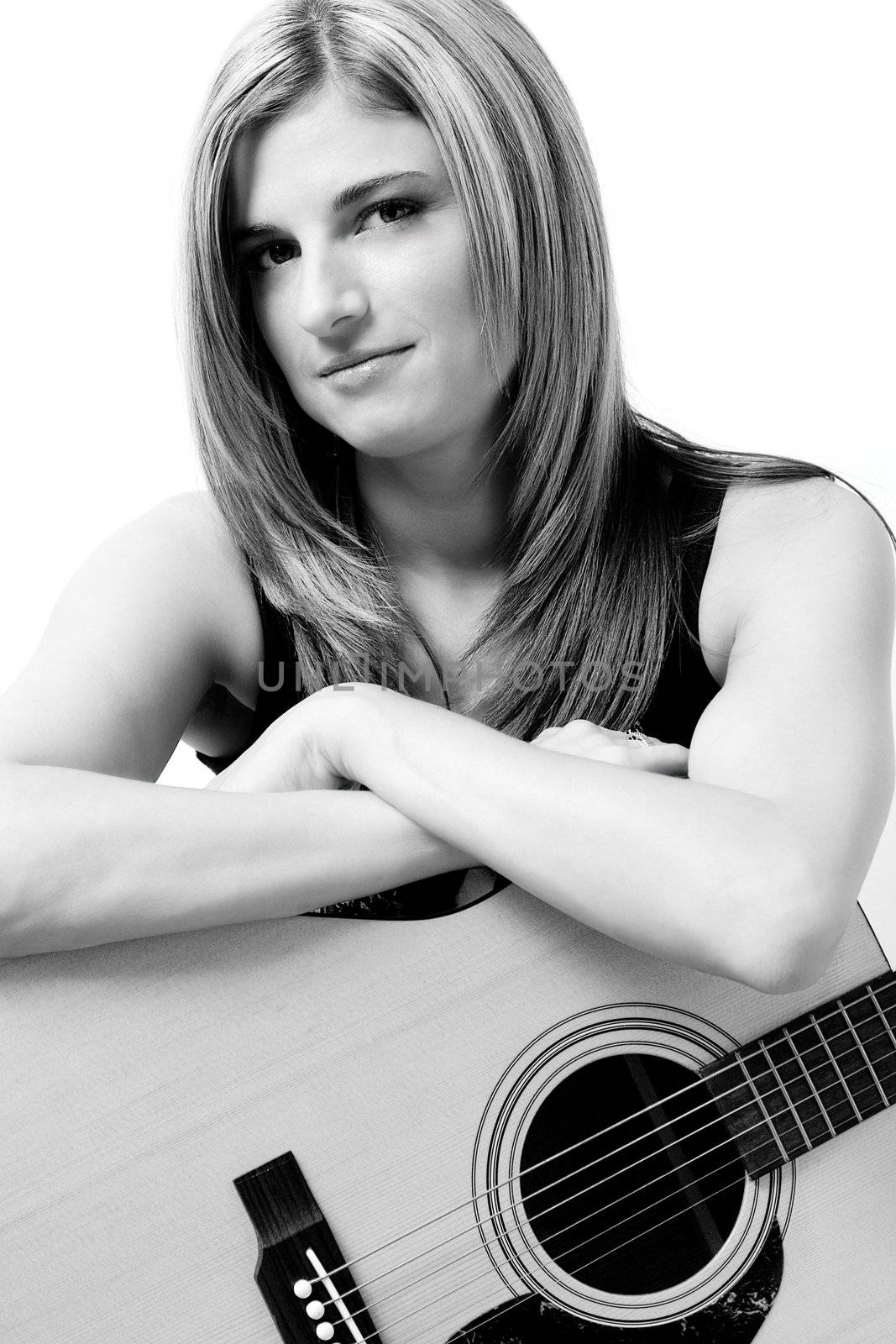 Thirty something women sitting on stule leaning on accoustic guitar