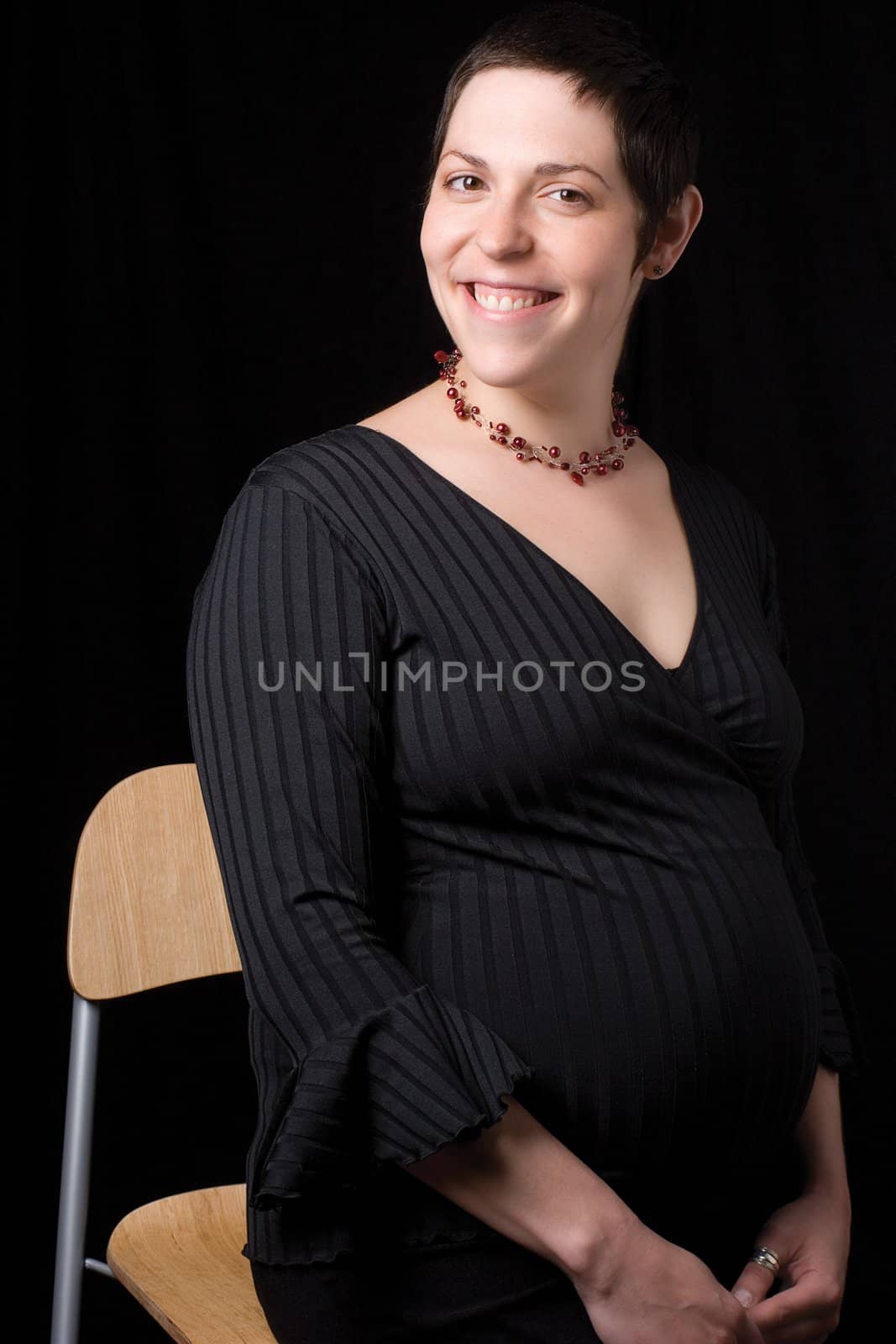 Sitting portrait of a late twenty pregnant women