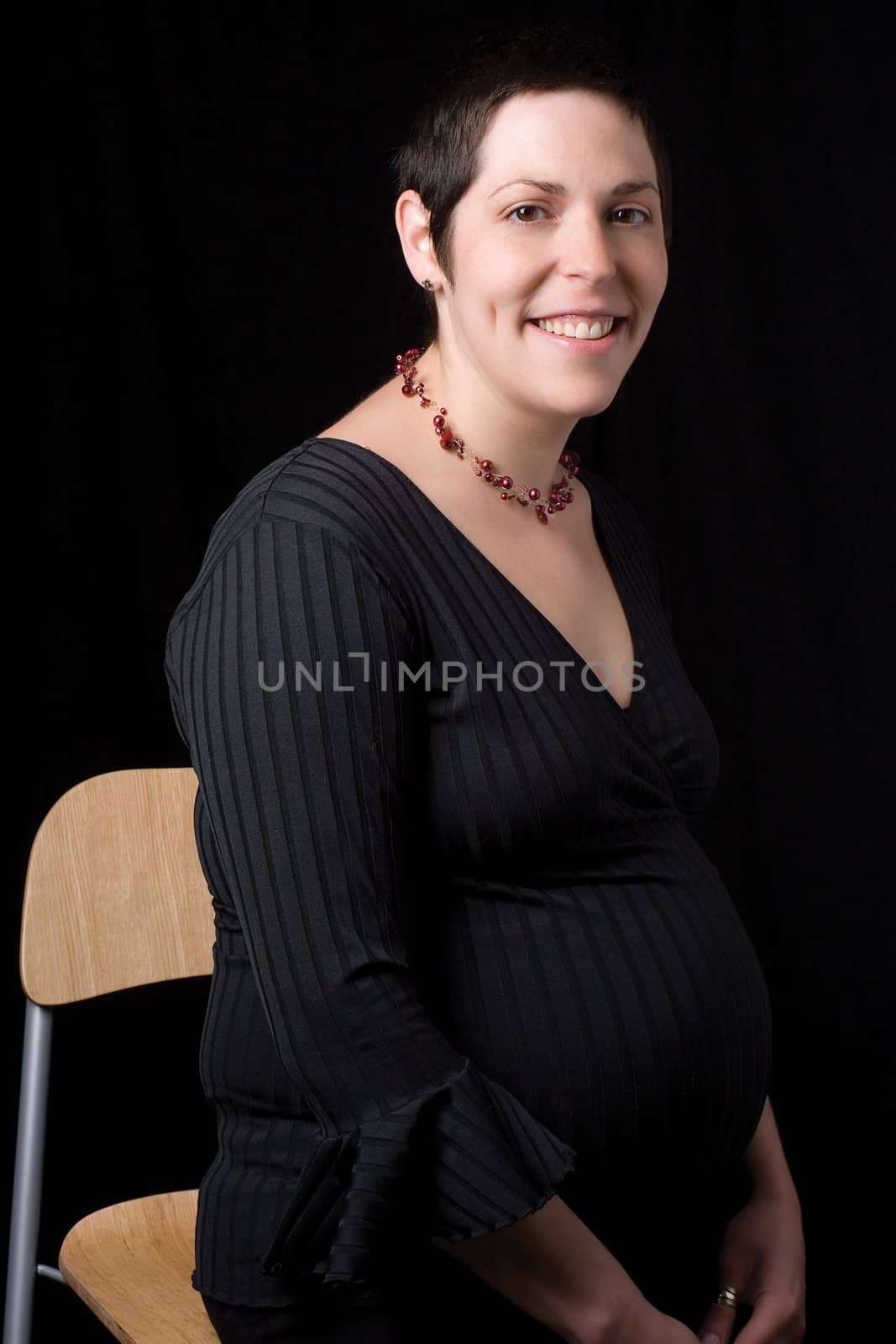 Sitting portrait of a late twenty pregnant women with relax attitude