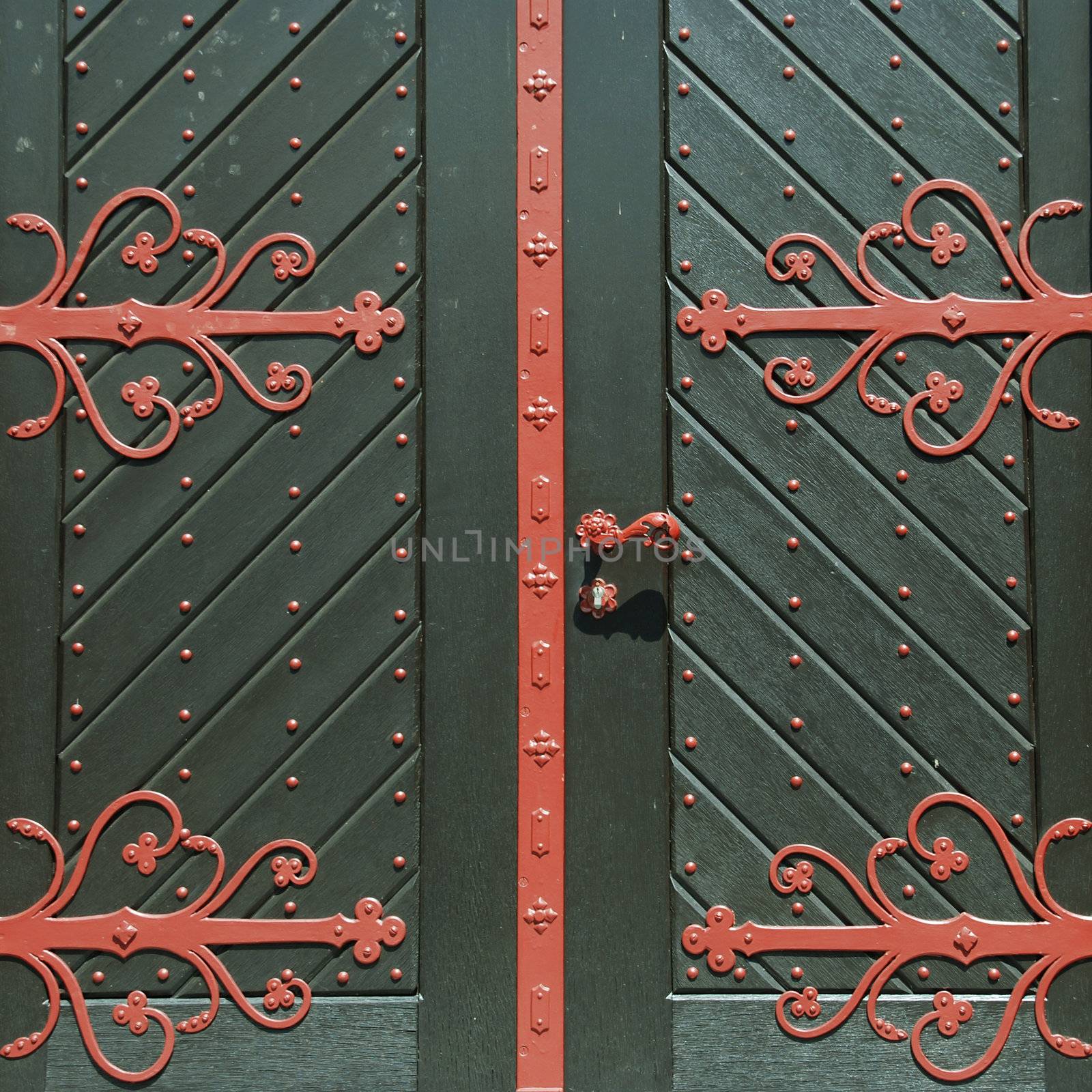 Closed green wooden door with red ornament
