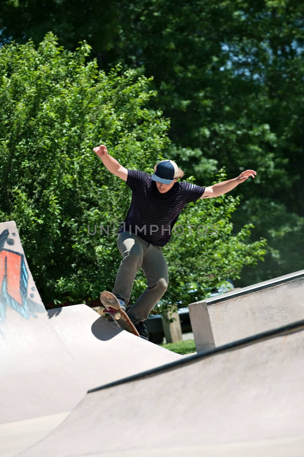 Action shot of a skateboarder going up a concrete skateboarding ramp at the skate park. Shallow depth of field.
