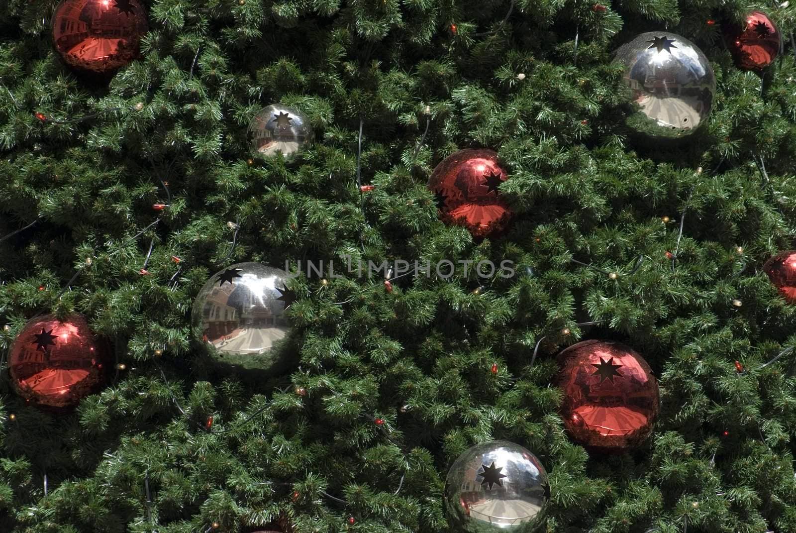 An artificial Christams tree background with red and silver metallic baubles